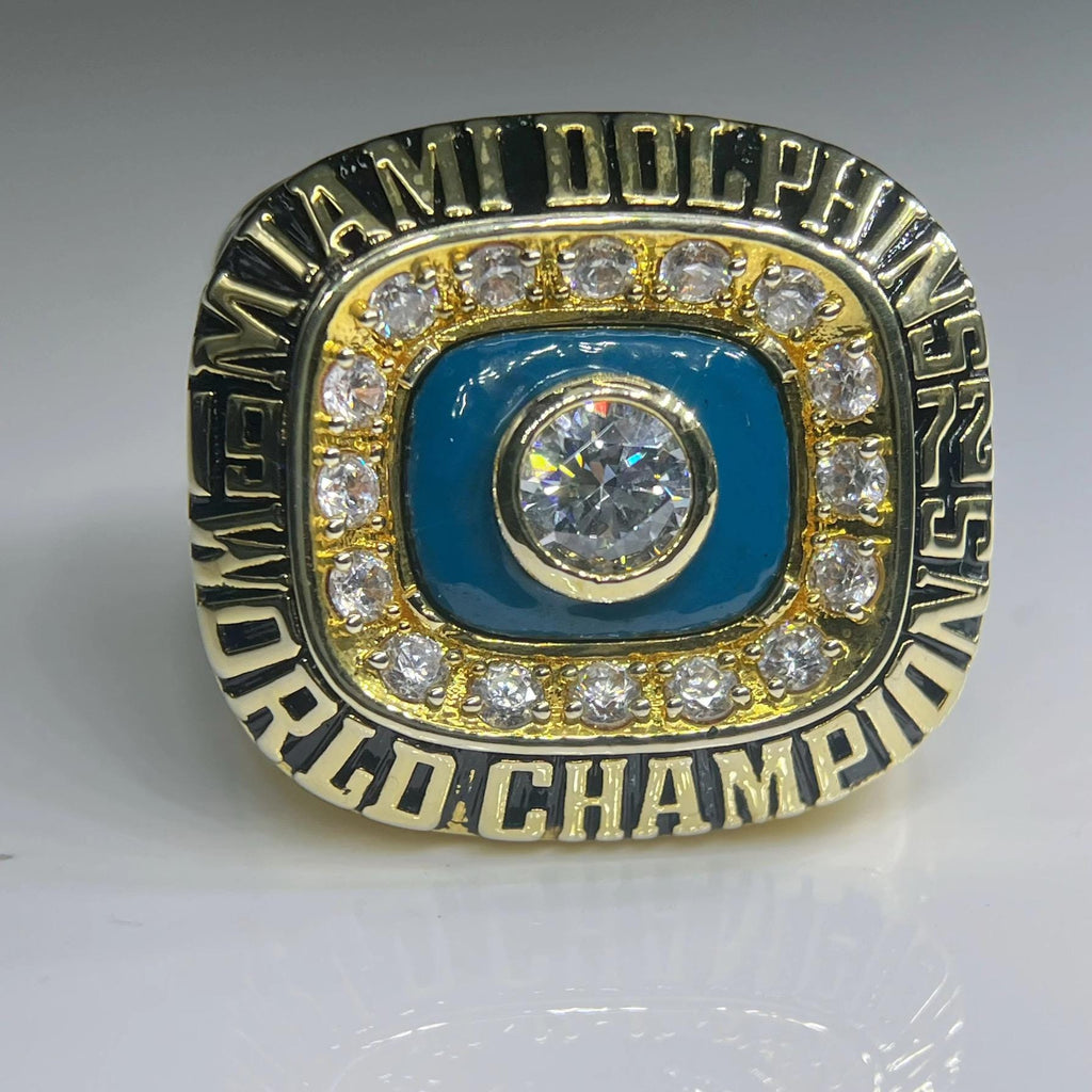 Miami Dolphins championship ring with gold and blue design on a gray background