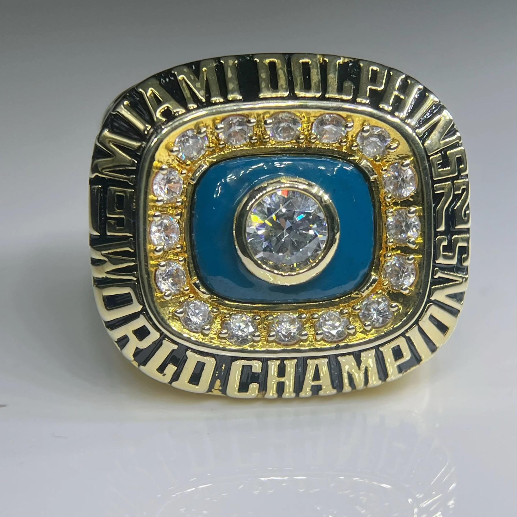 Miami Dolphins championship ring with gold and blue design on a gray background