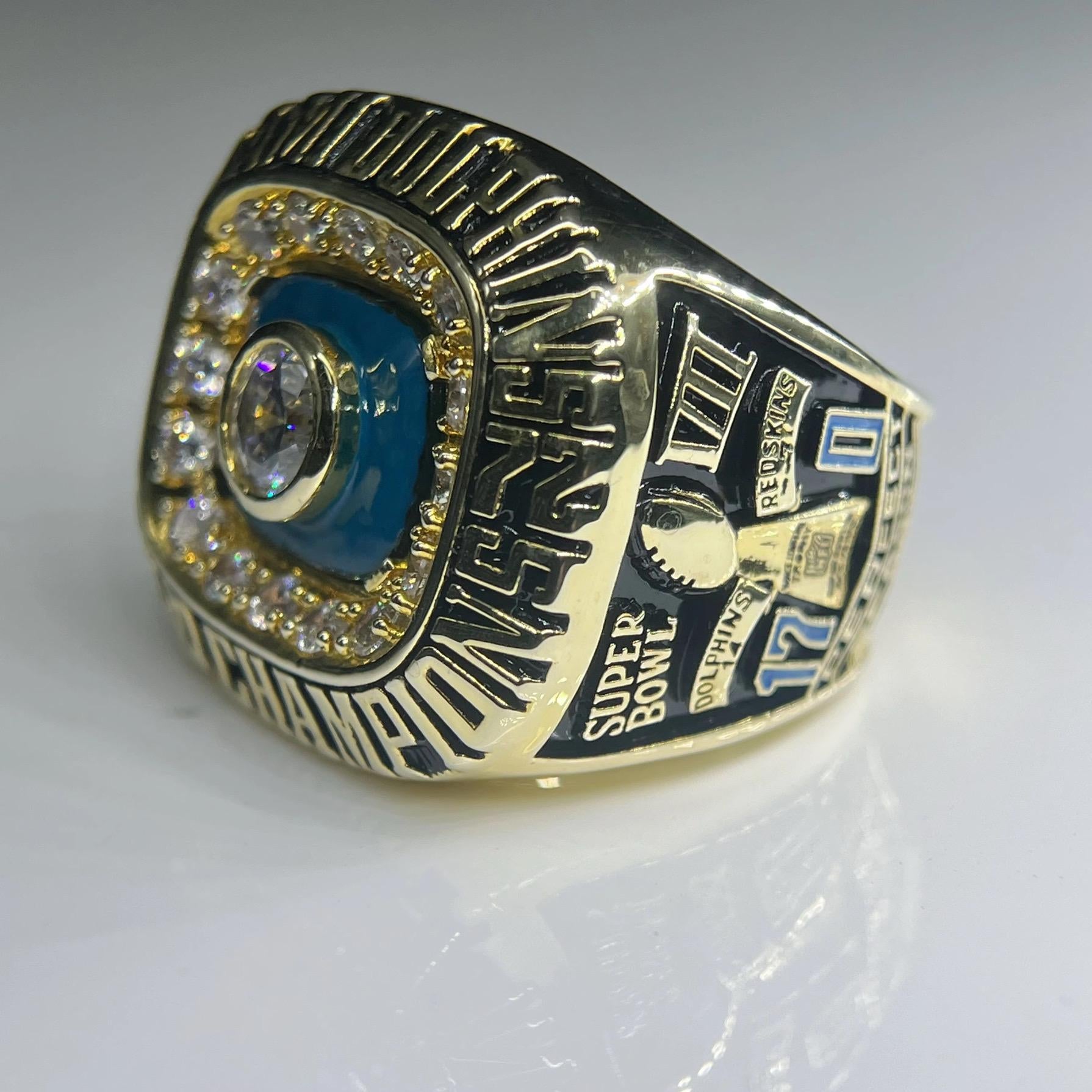 Gold championship ring with blue and black details on a white background
