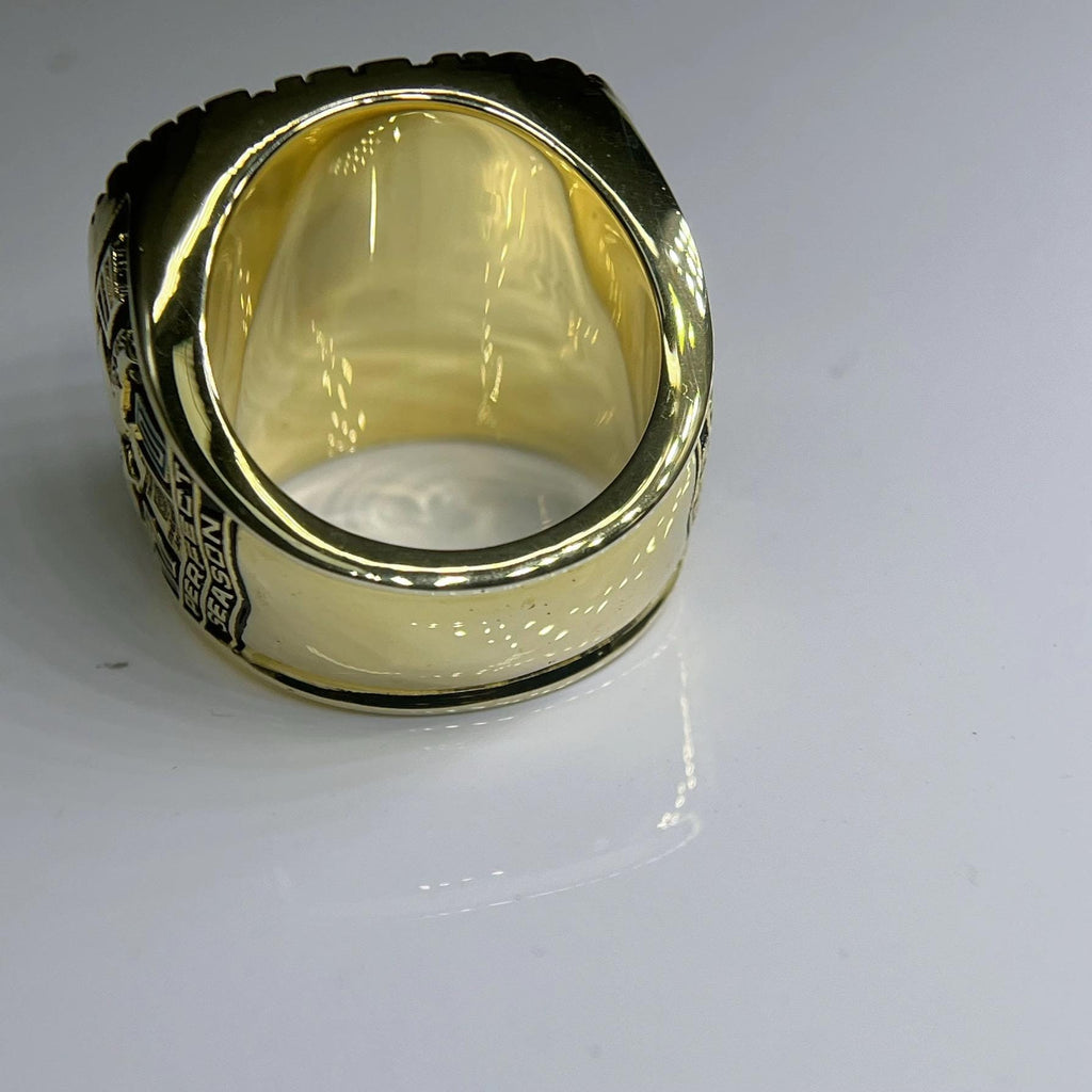 Gold ring with engraved design on a white background