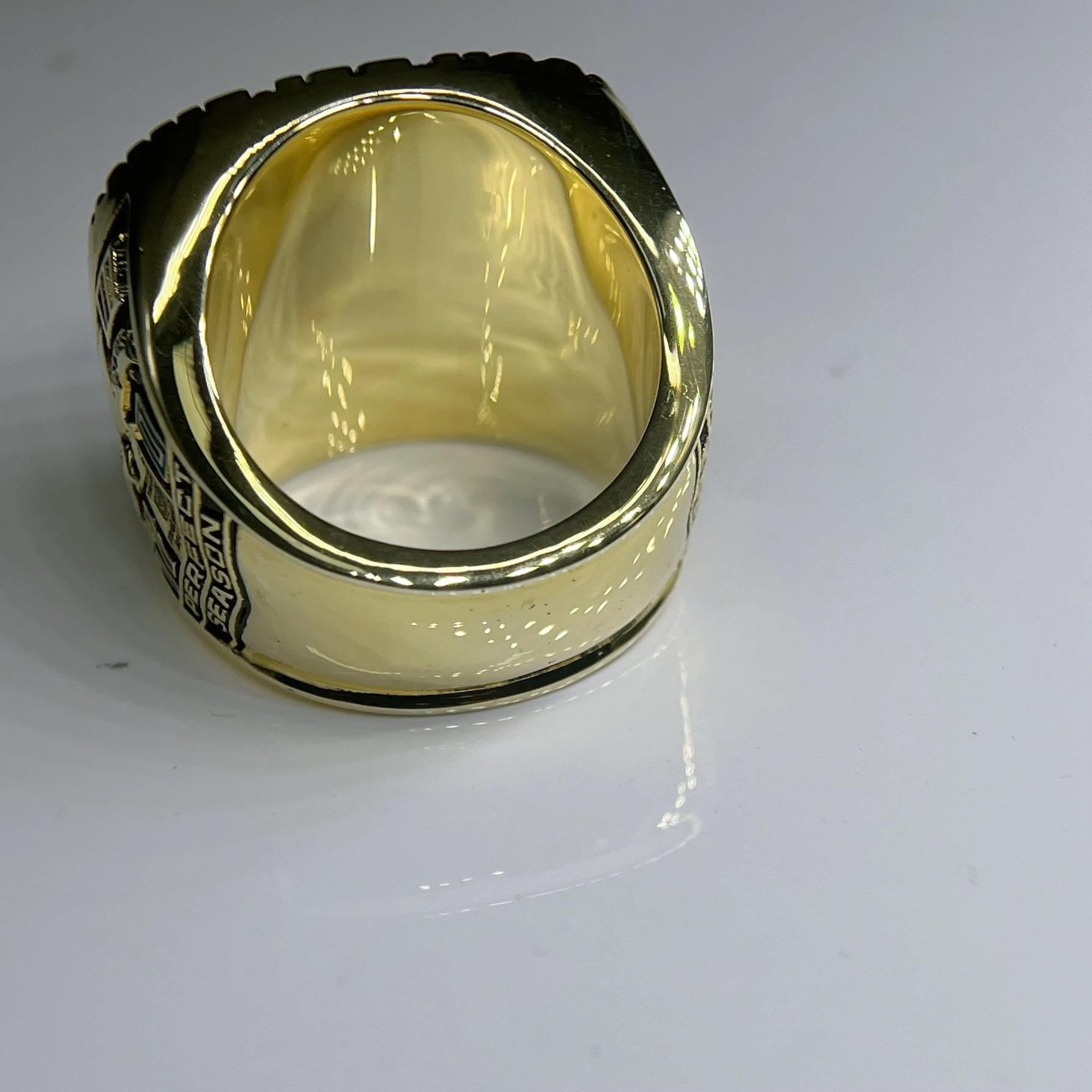 Gold ring with engraved design on a white background