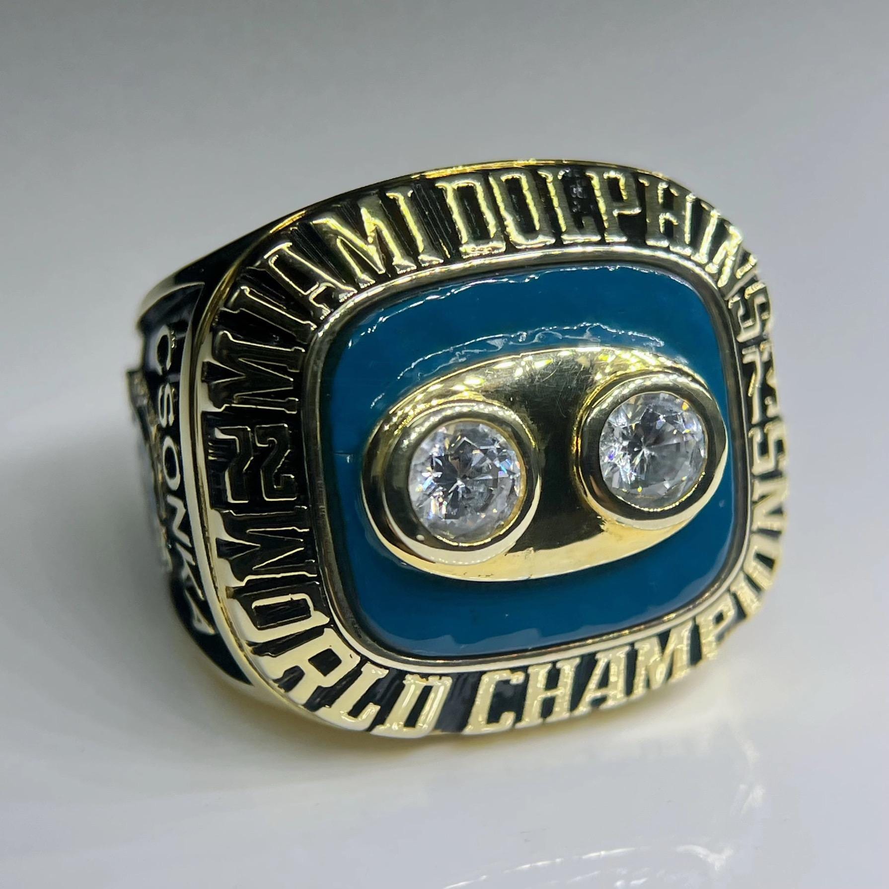 Ring with 'Miami Dolphins' and 'World Champion' text on a gray background
