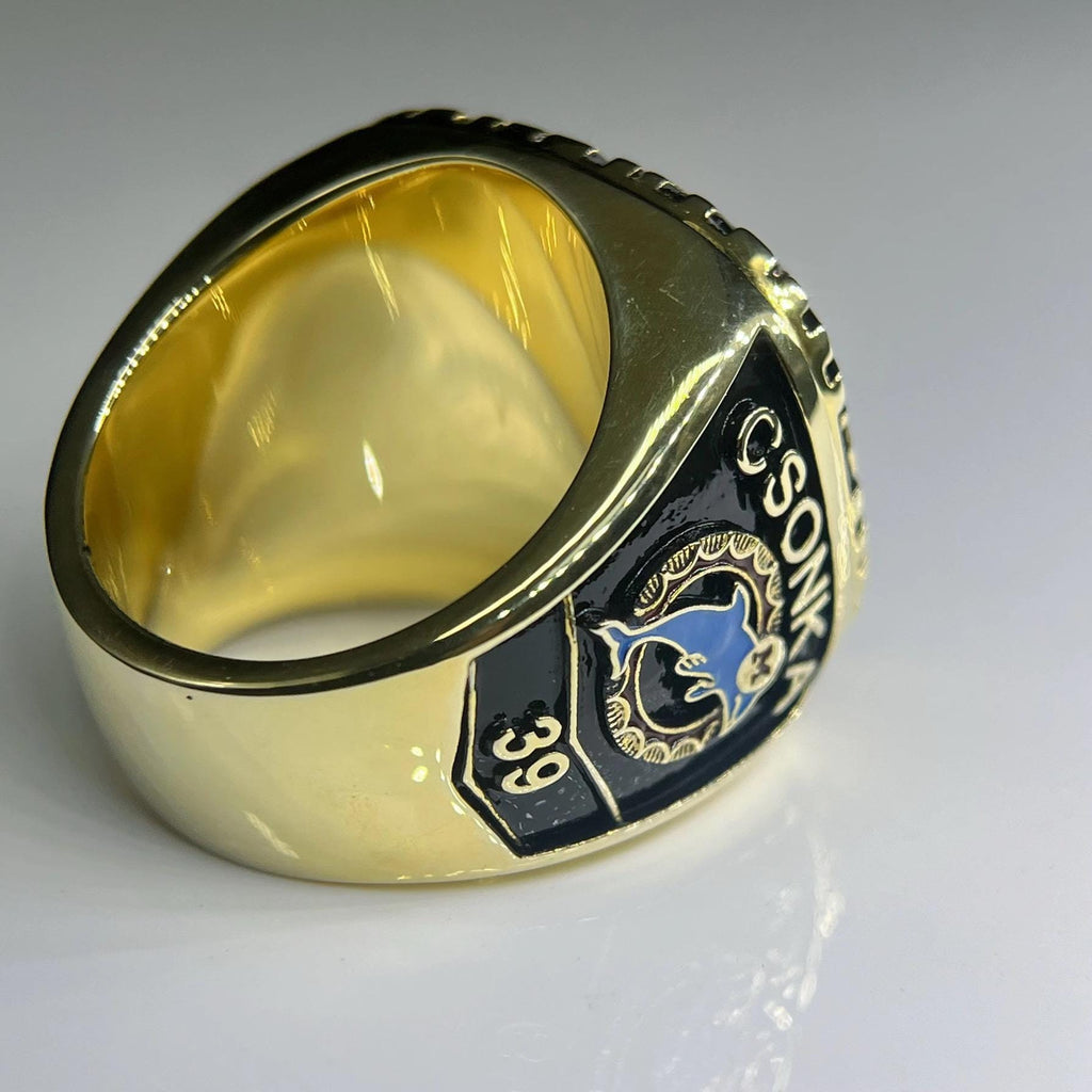 Gold ring with a black and blue emblem on a white background
