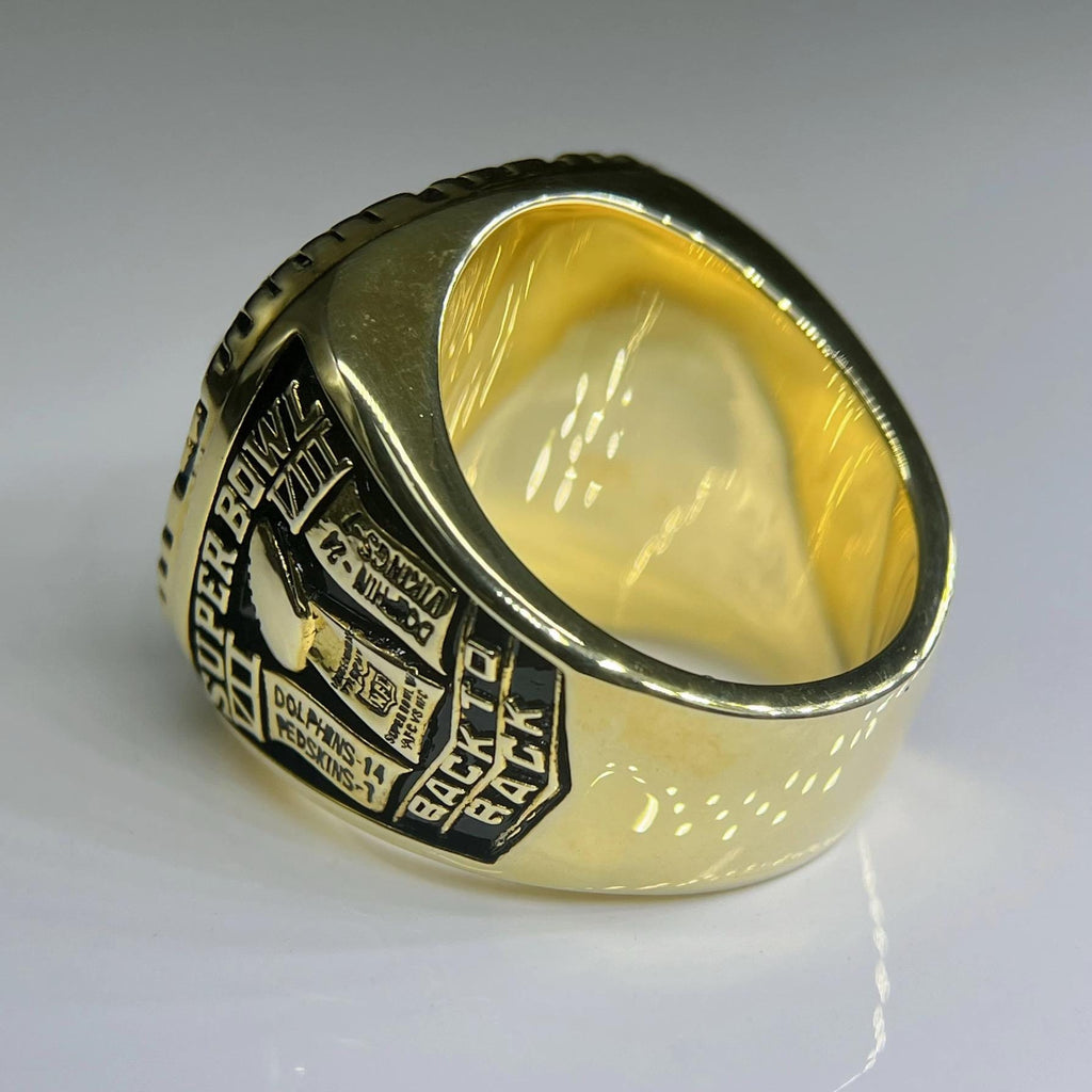 Gold ring with engraved text on a gray background