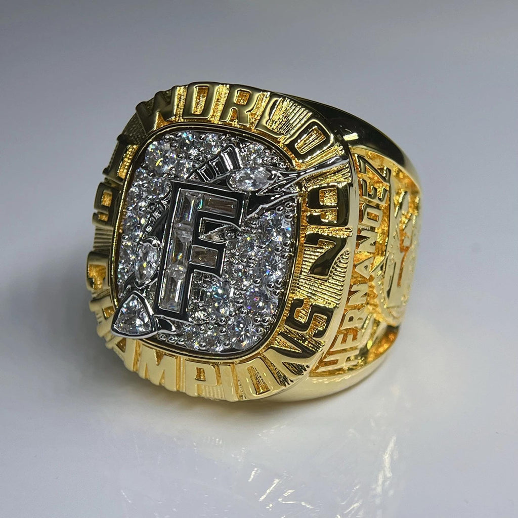 Gold championship ring with diamonds on a gray background