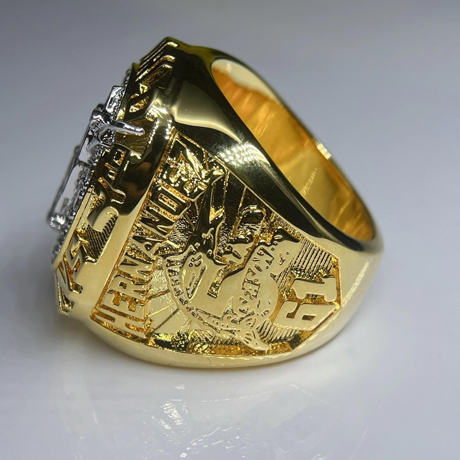 Gold ring with detailed design on a gray background