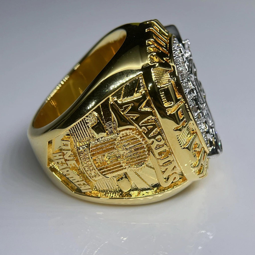 Gold ring with detailed design on a gray background