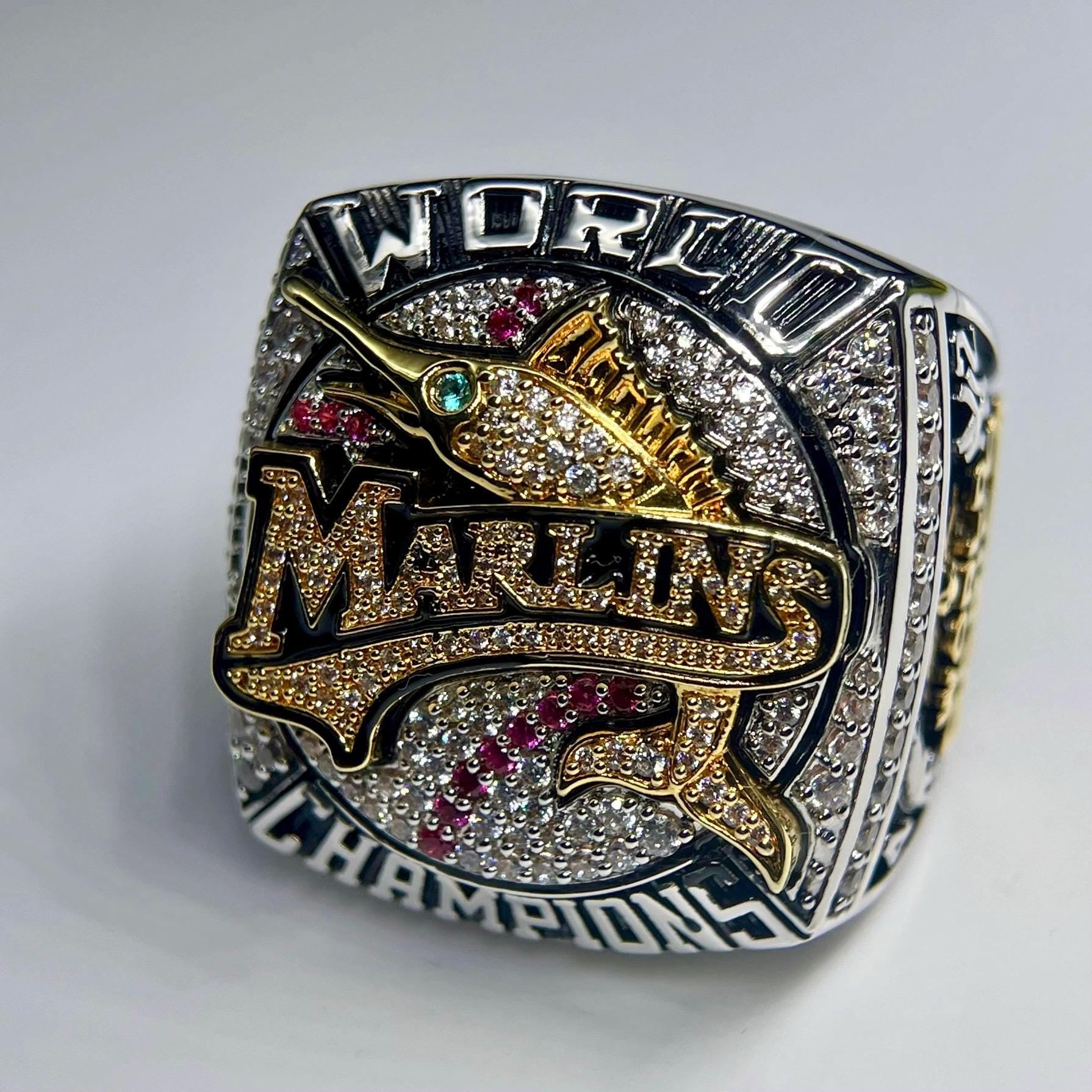 World Series championship ring with 'Miami Marlins' text on a white background