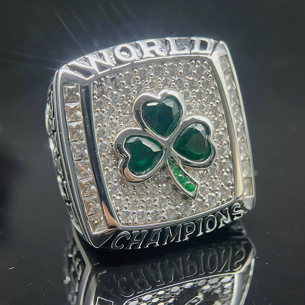Silver championship ring with green shamrock design on a reflective surface