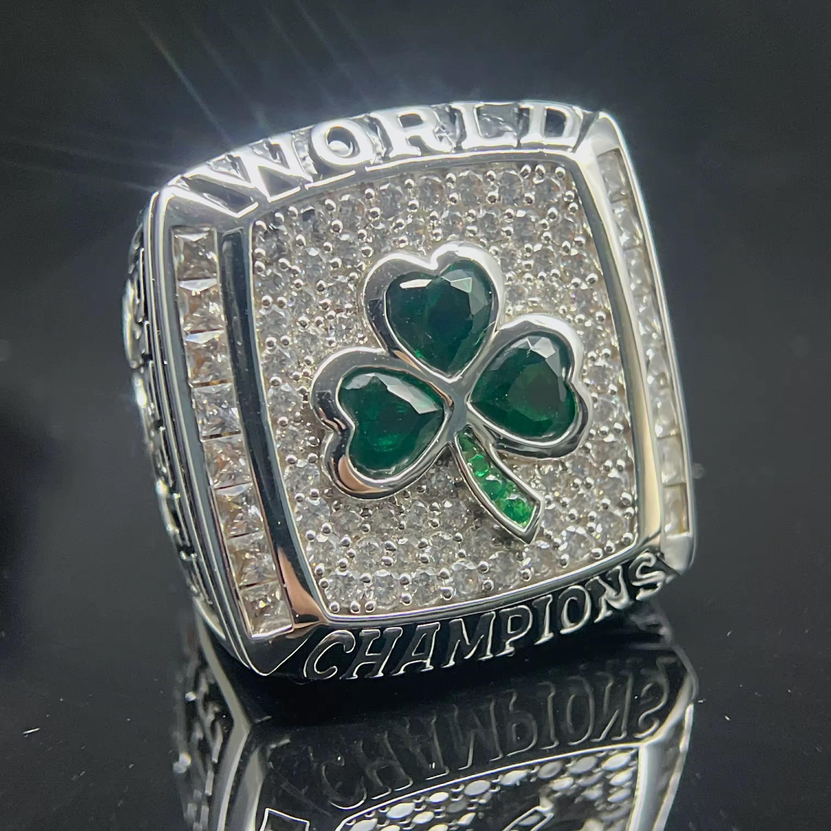 Silver championship ring with green shamrock design on a reflective surface