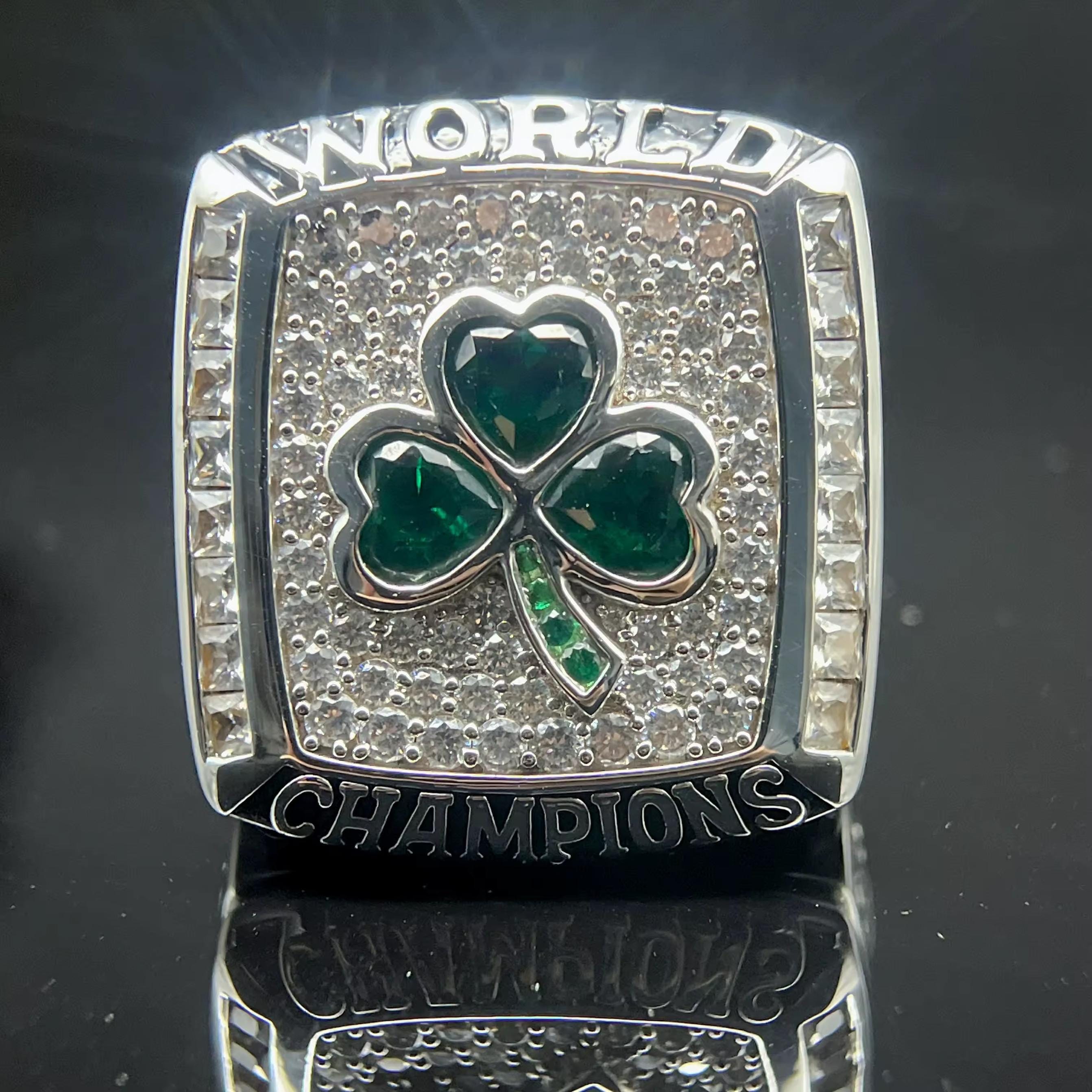 Silver championship ring with a shamrock design on a reflective black surface