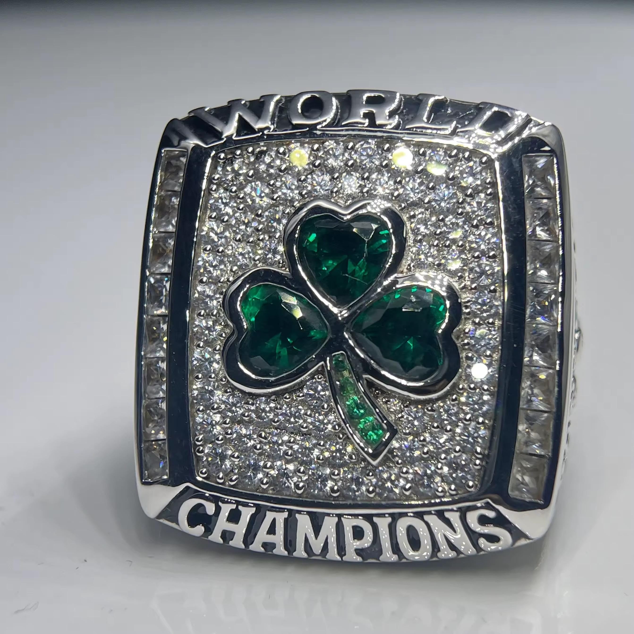 Ring with green shamrock design and 'World Champions' text on a gray background