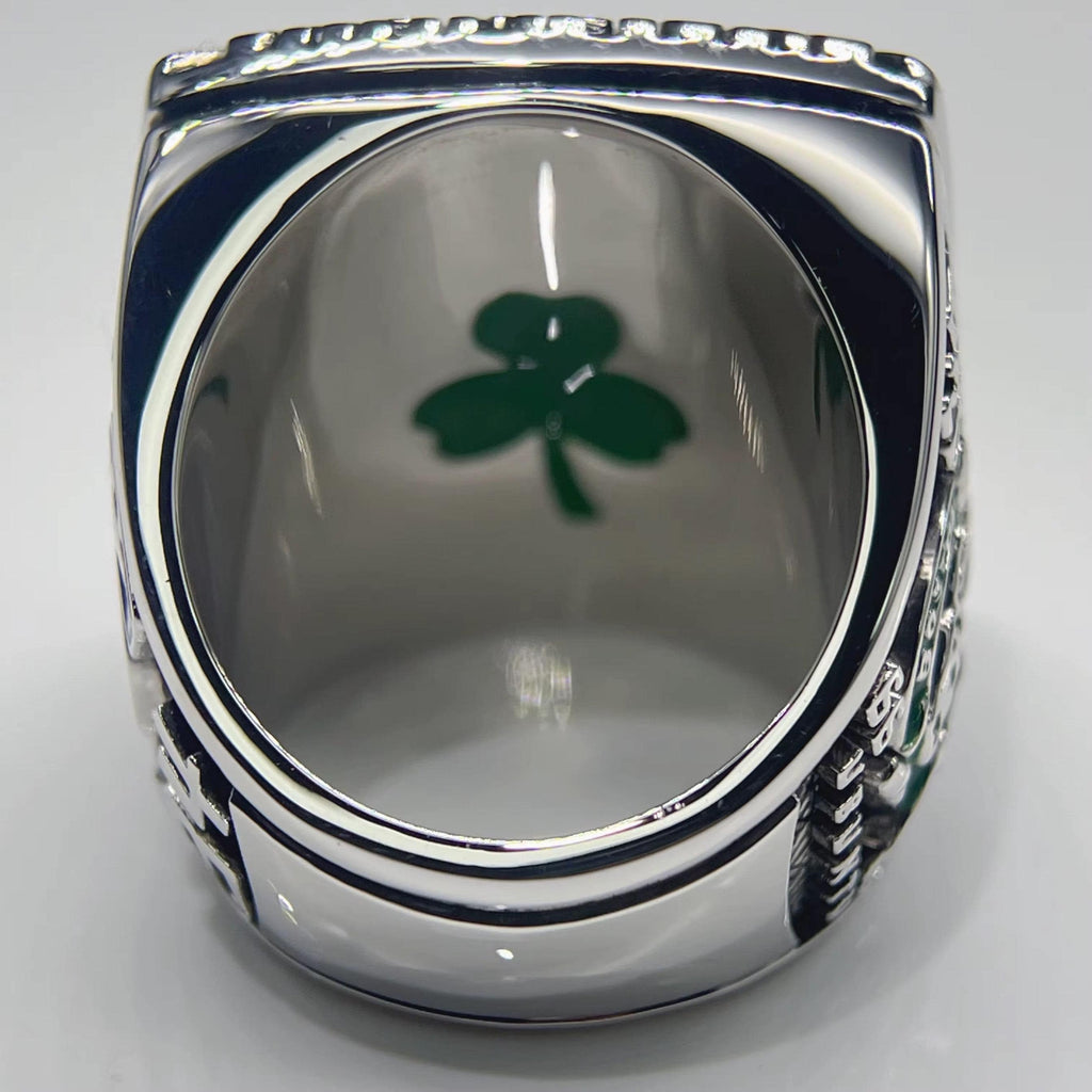 Silver ring with a green clover design on a gray background
