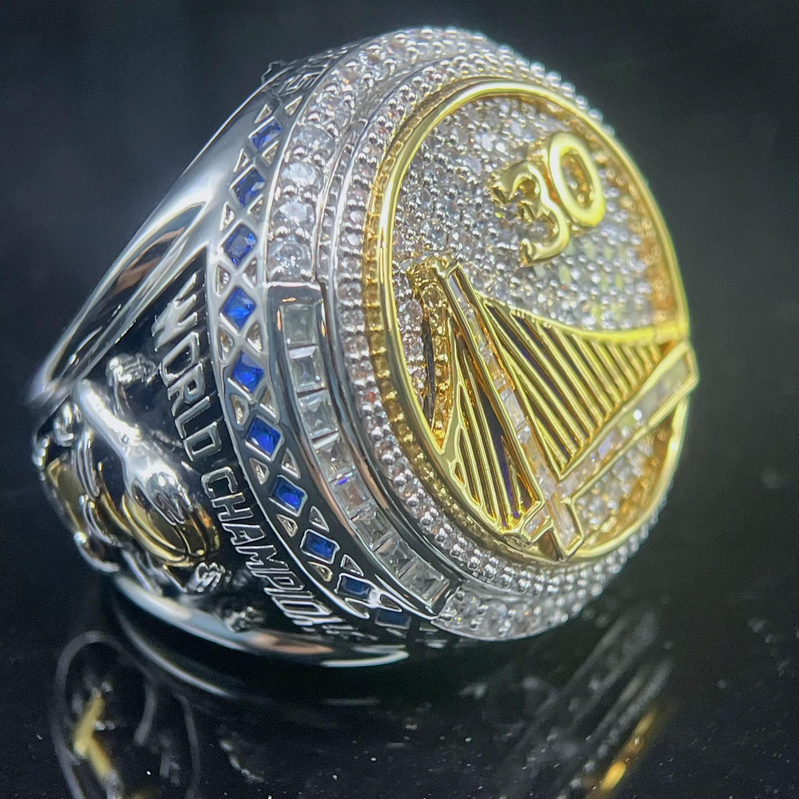 Gold and silver ring with 'Warriors' and number '30' on a dark background