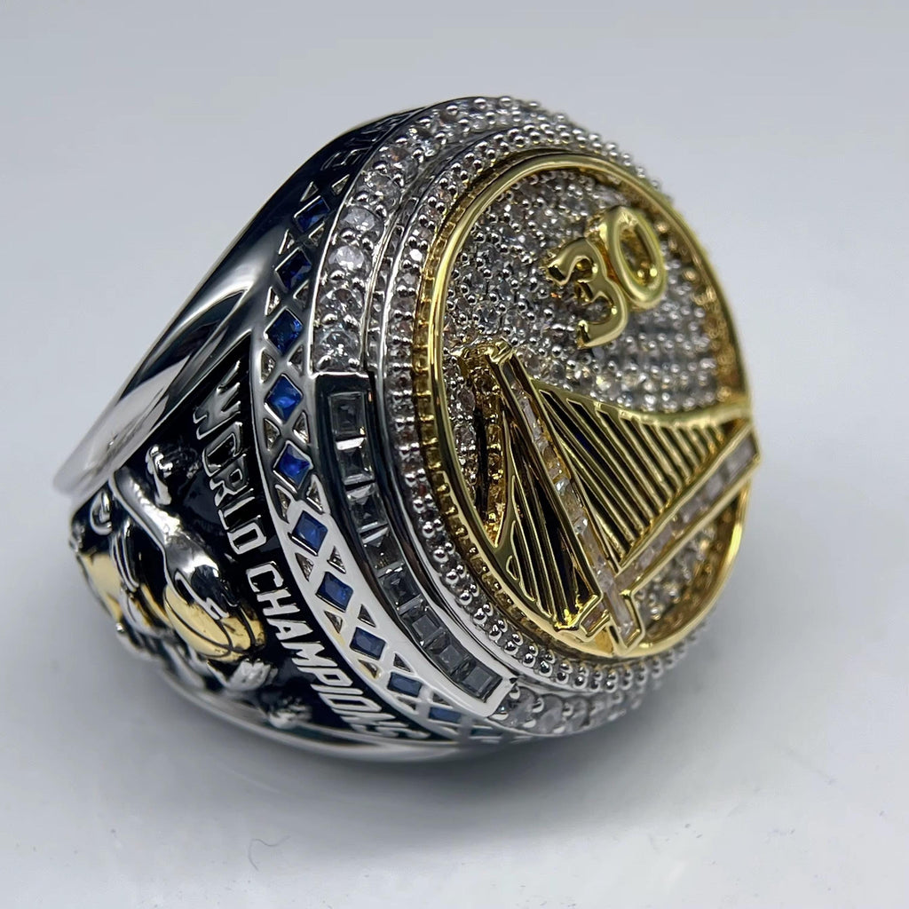 Silver and gold championship ring with 'World Champions' text on a white background