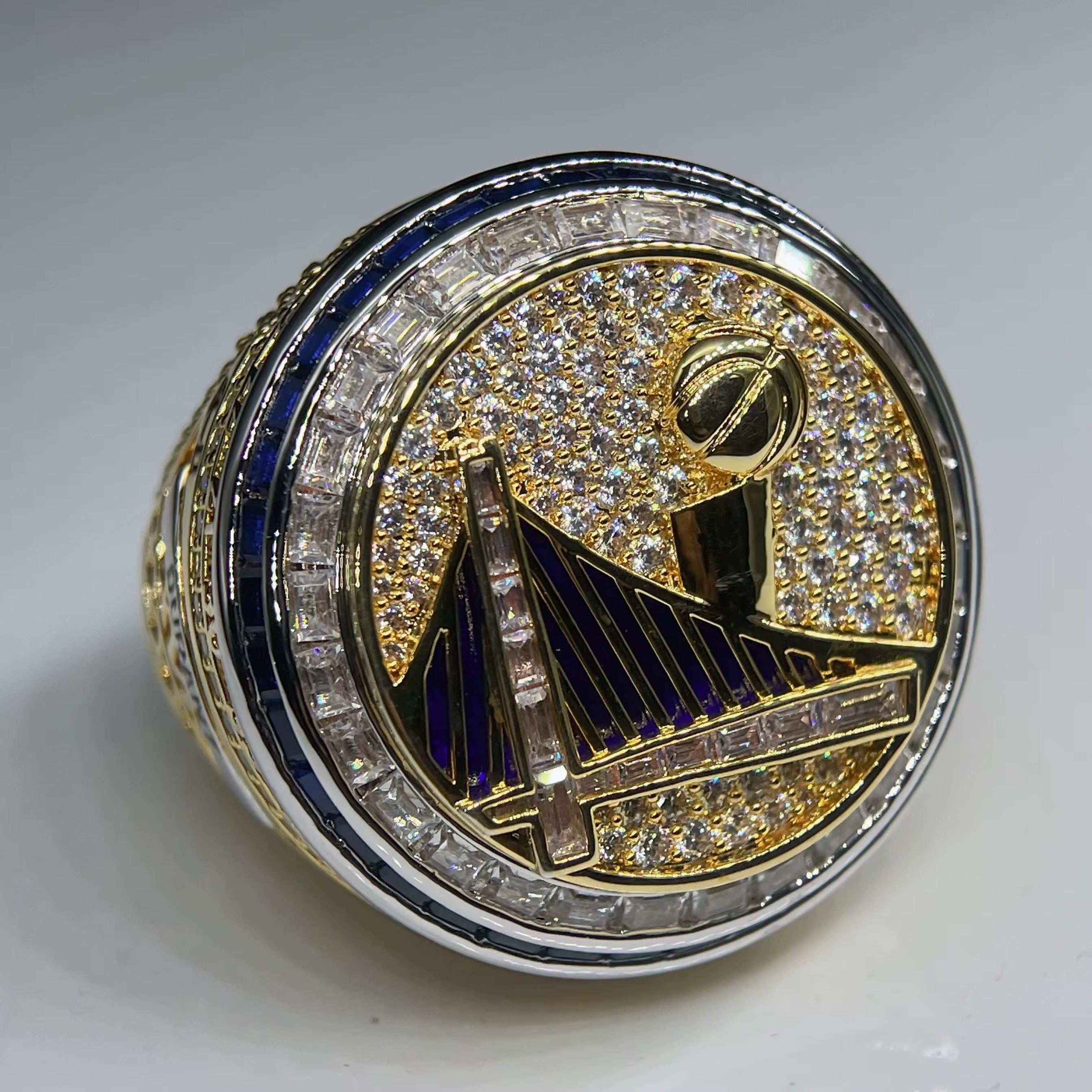 Gold and silver ring with intricate design on a white background