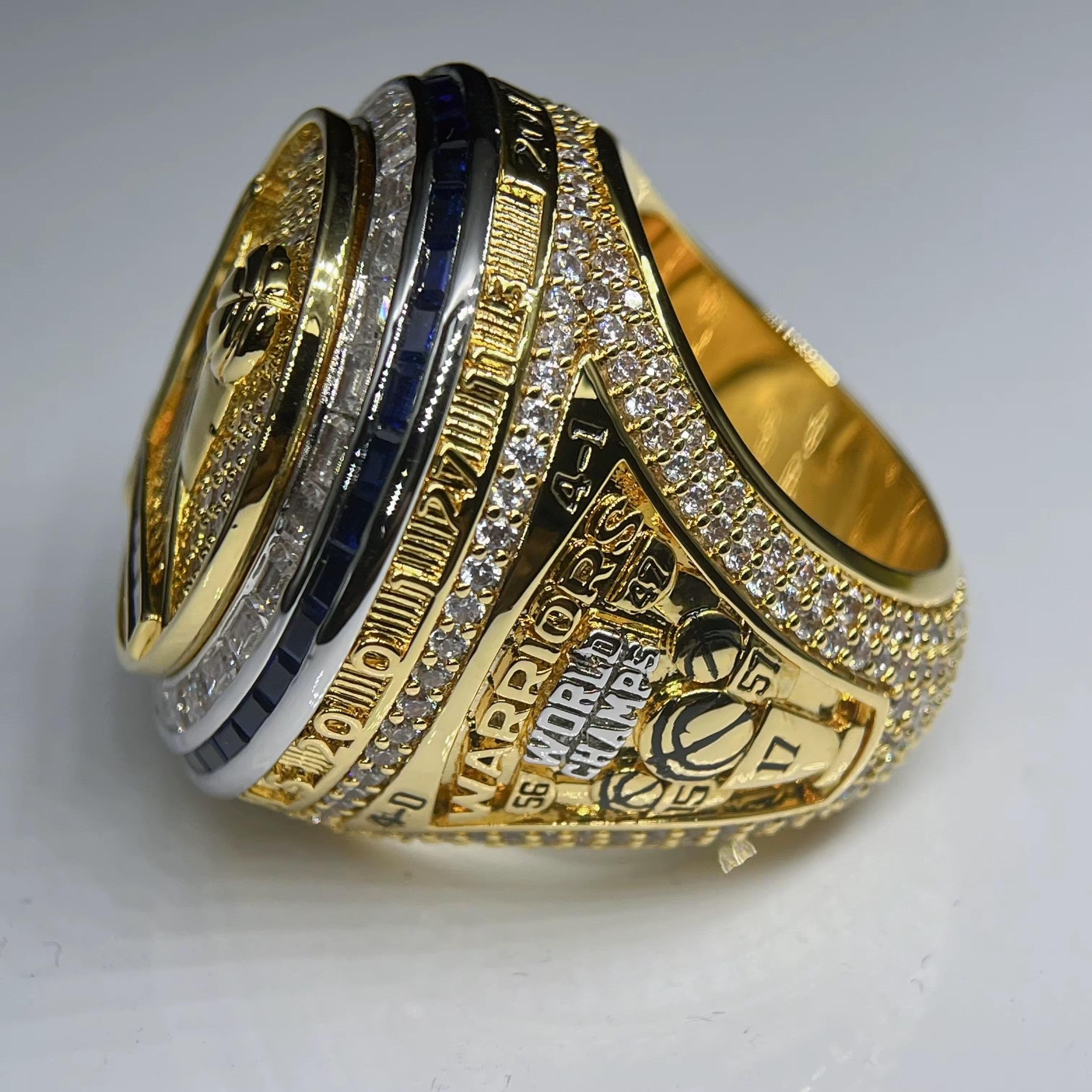 Gold championship ring with engraved text on a gray background
