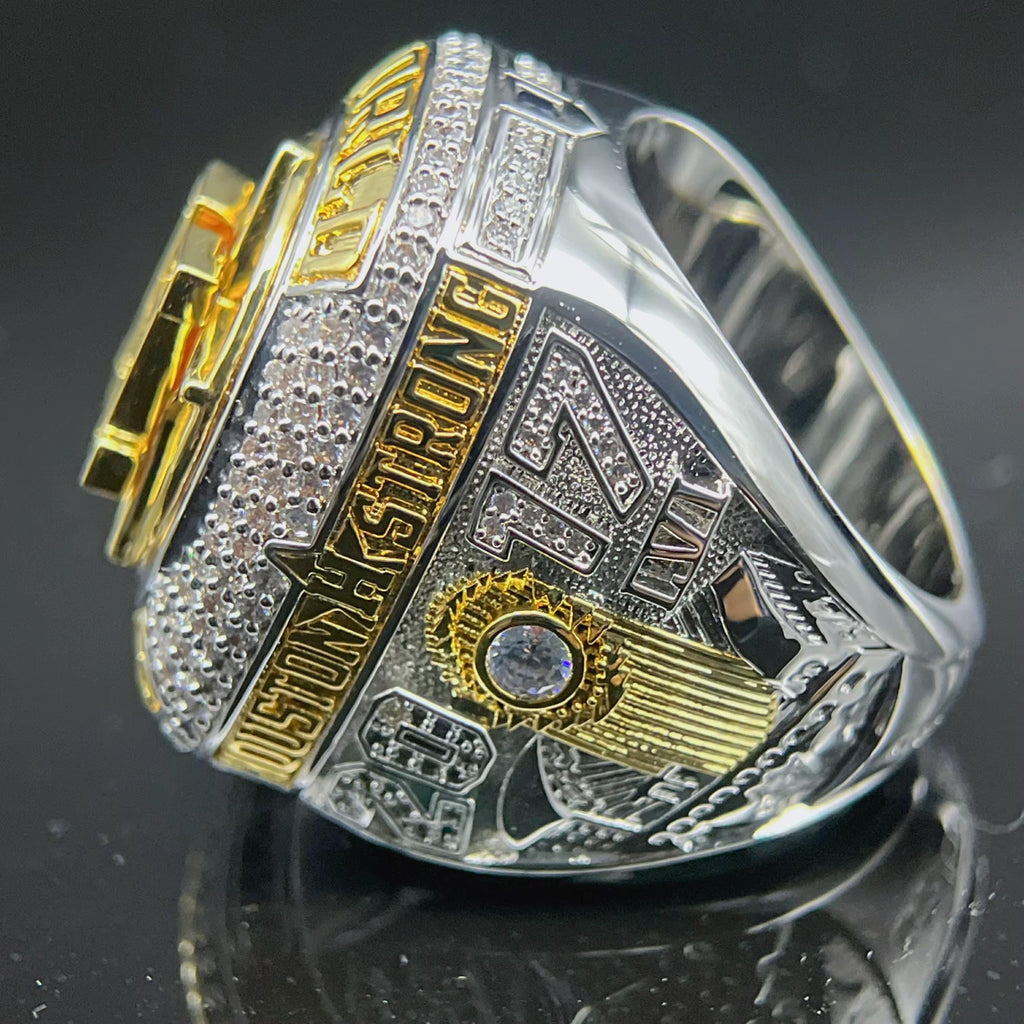 Gold and silver ring with intricate design on a reflective surface