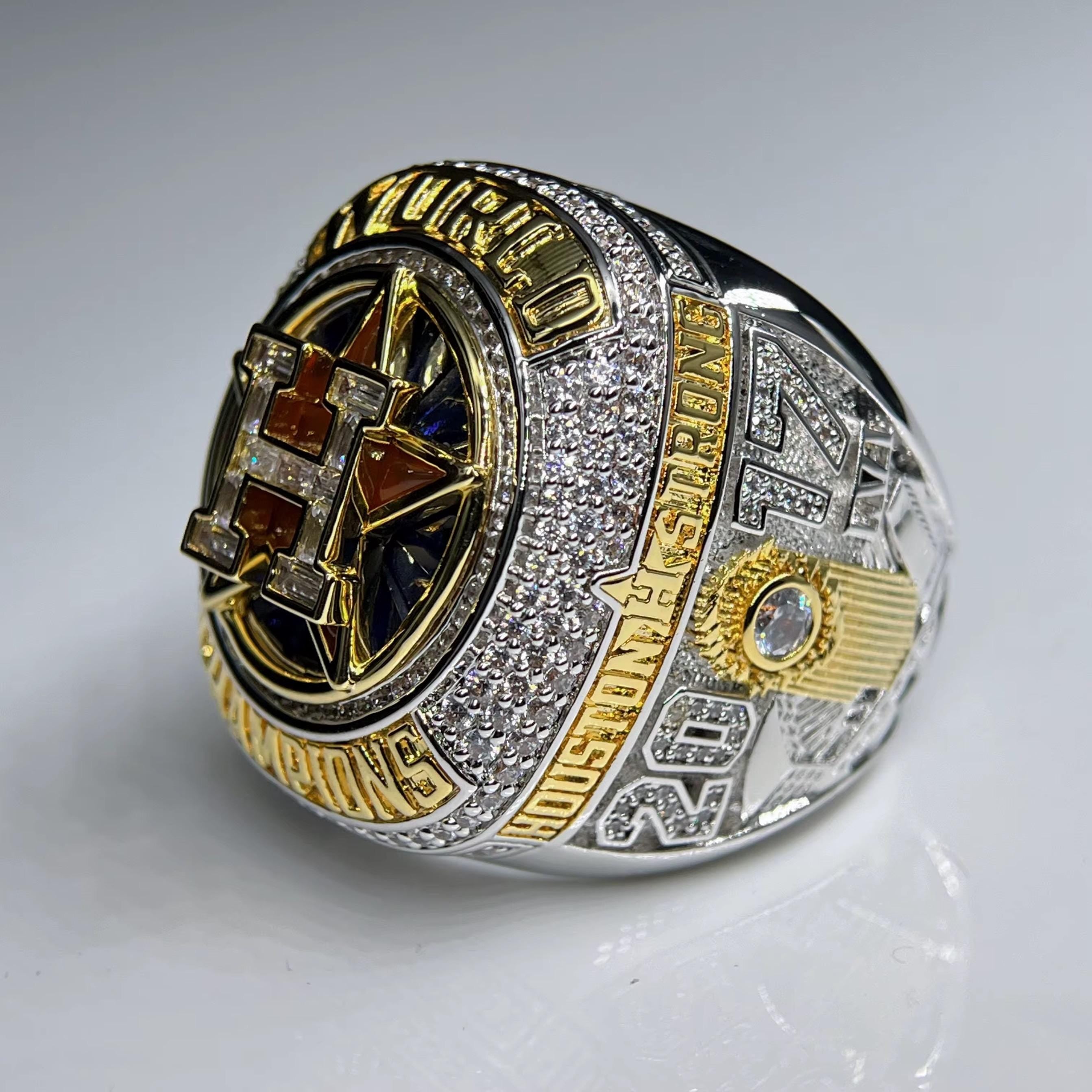 Close-up of a championship ring with detailed design on a gray background