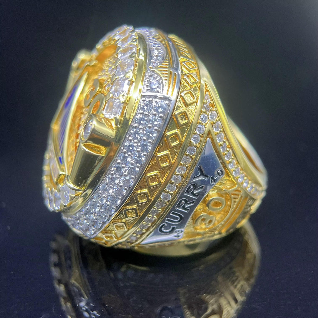 Gold and silver ring with 'Curry' branding on a dark background