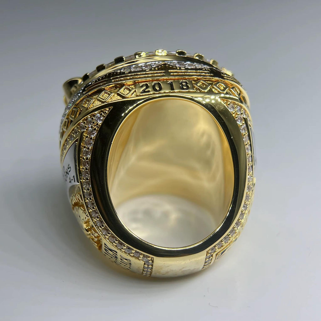 Gold ring with '2018' on a gray background