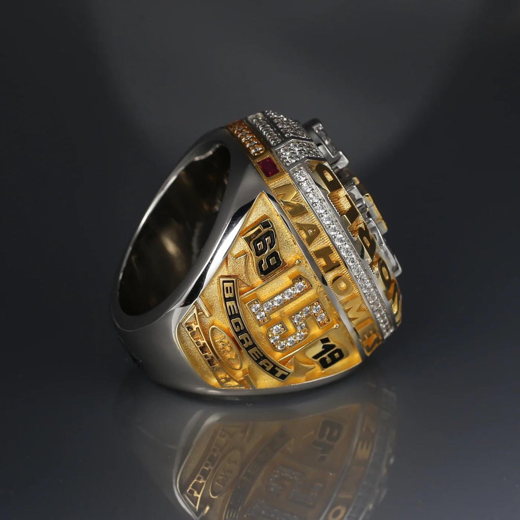 Gold and silver ring with engraved text on a reflective surface