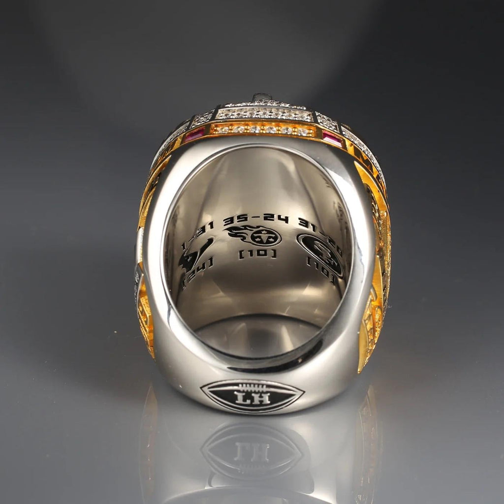Close-up of a silver ring with gold accents on a reflective surface