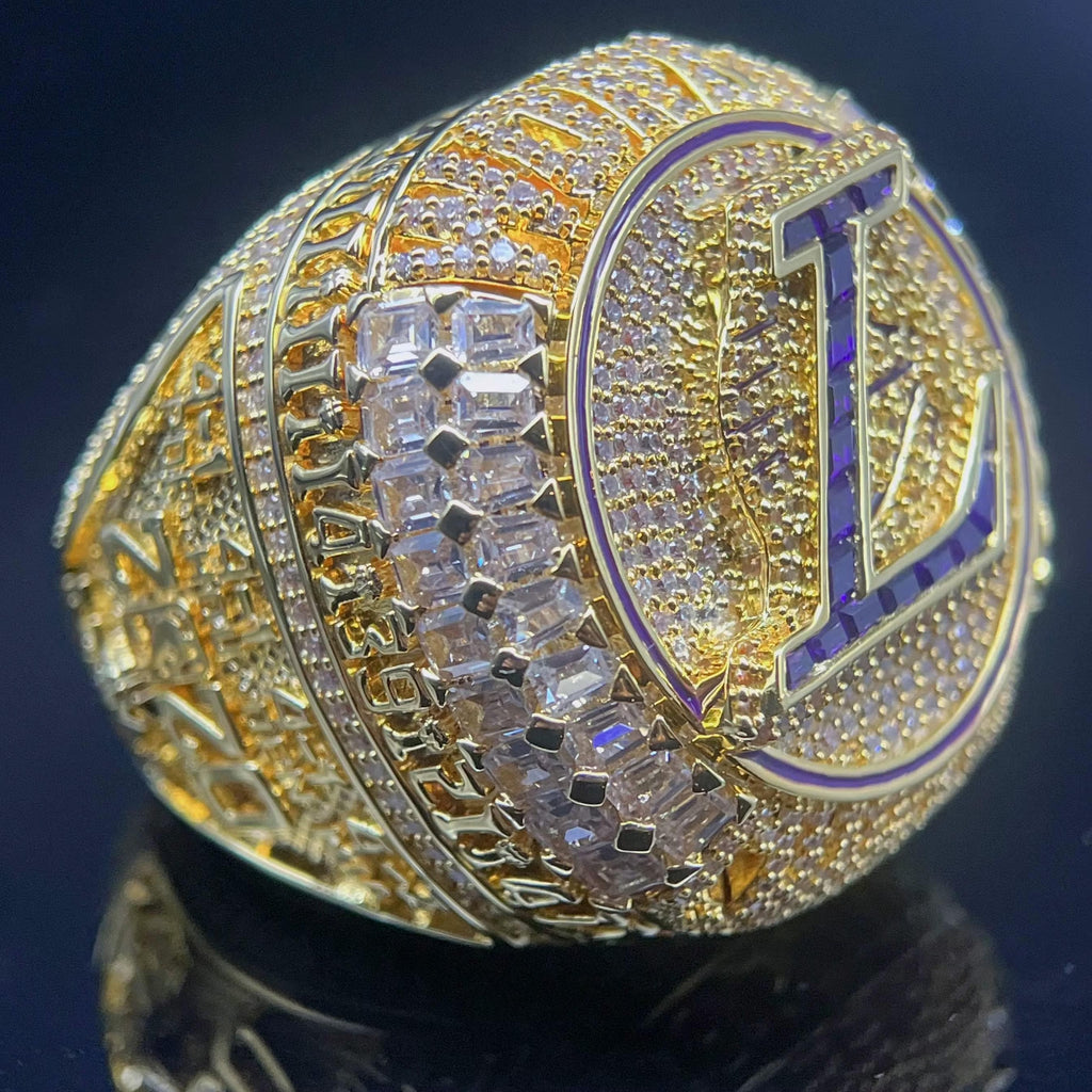 Gold championship ring with diamonds and a prominent 'L'