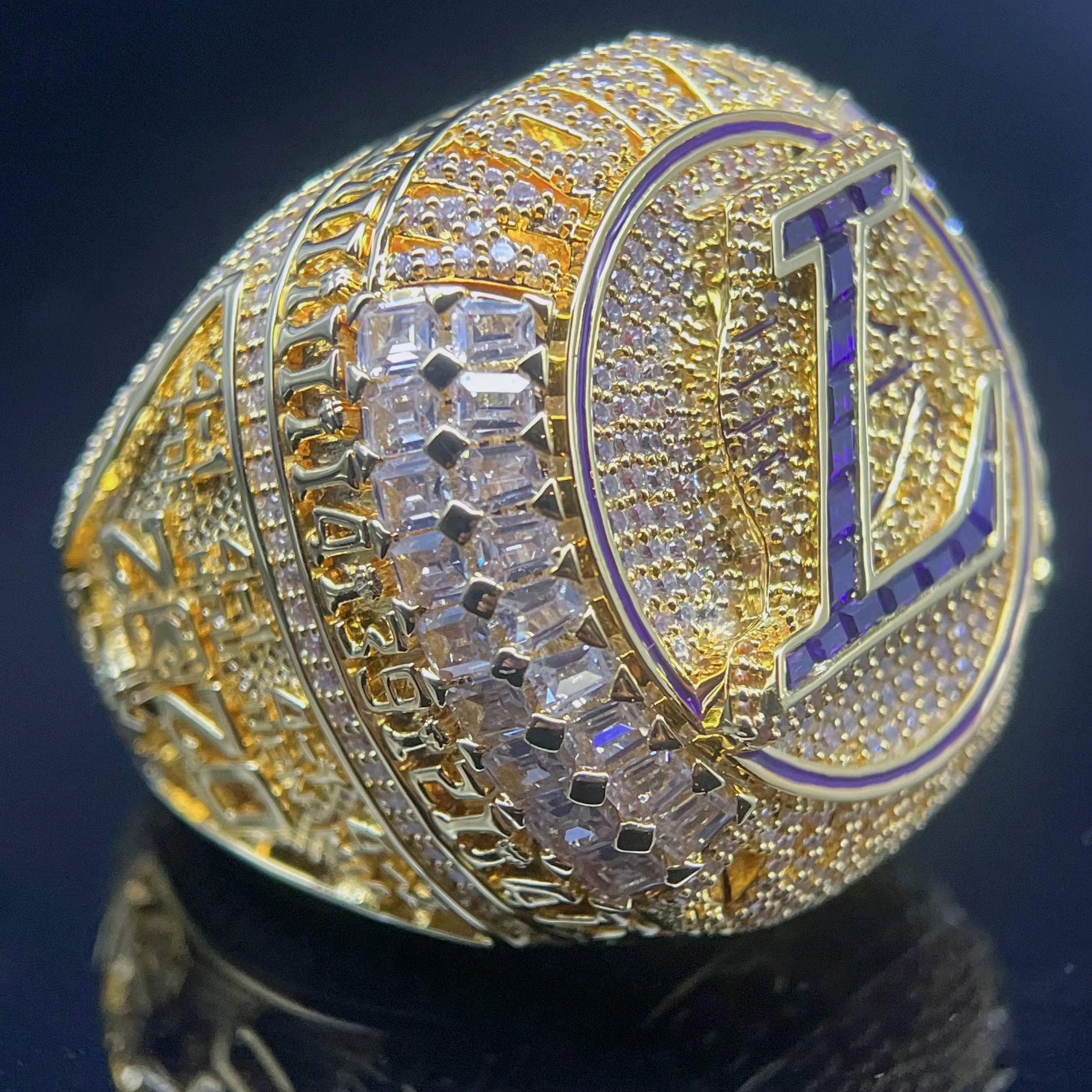 Gold championship ring with diamonds and a prominent 'L'