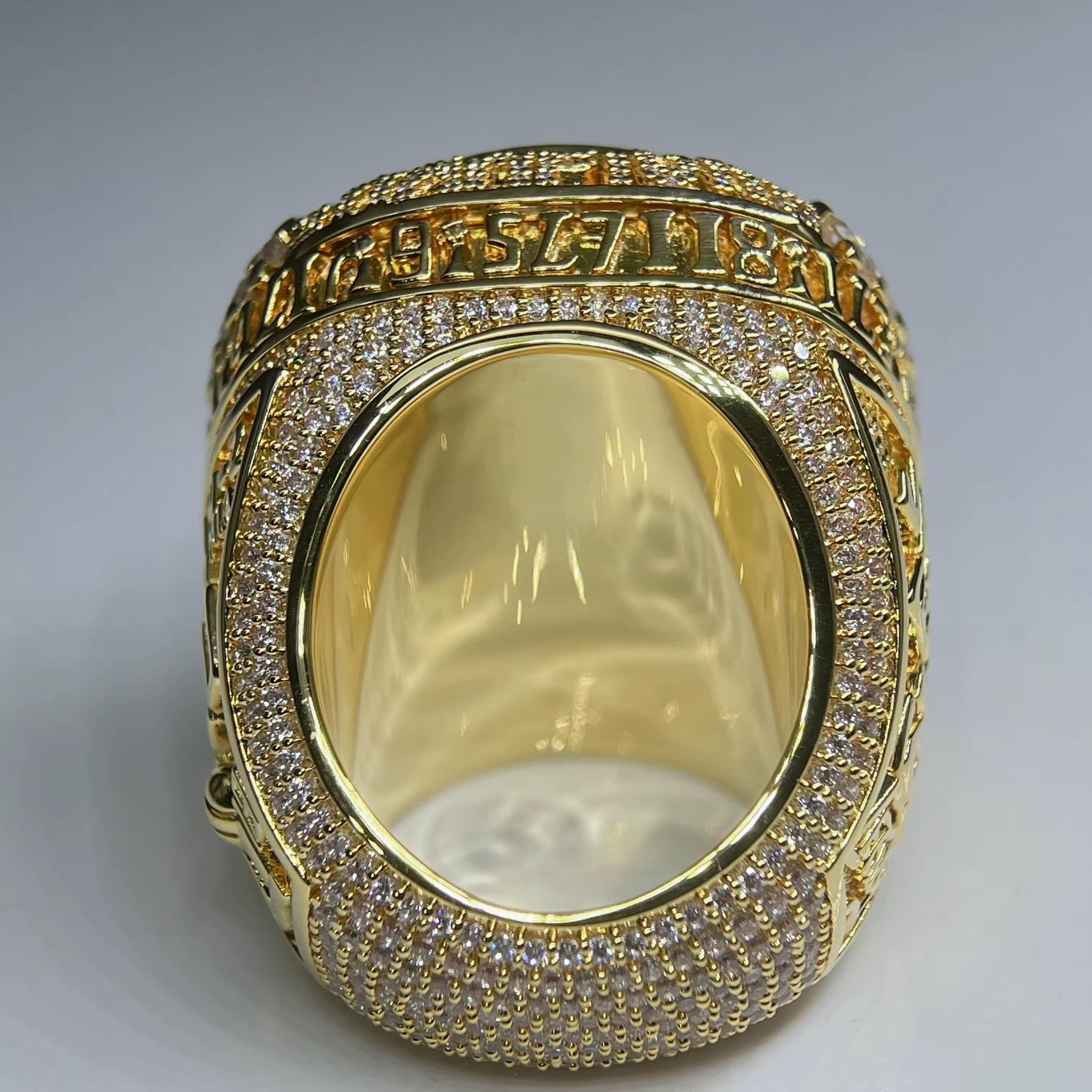 Gold ring with diamond accents on a gray background