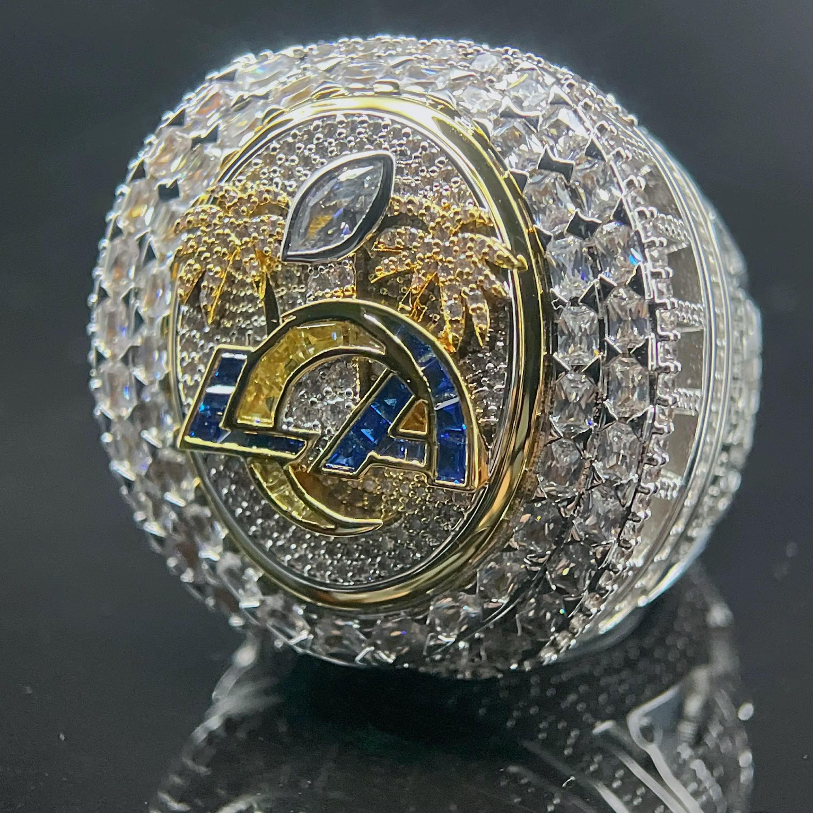 Luxury sports team logo ring with crystals on a reflective surface
