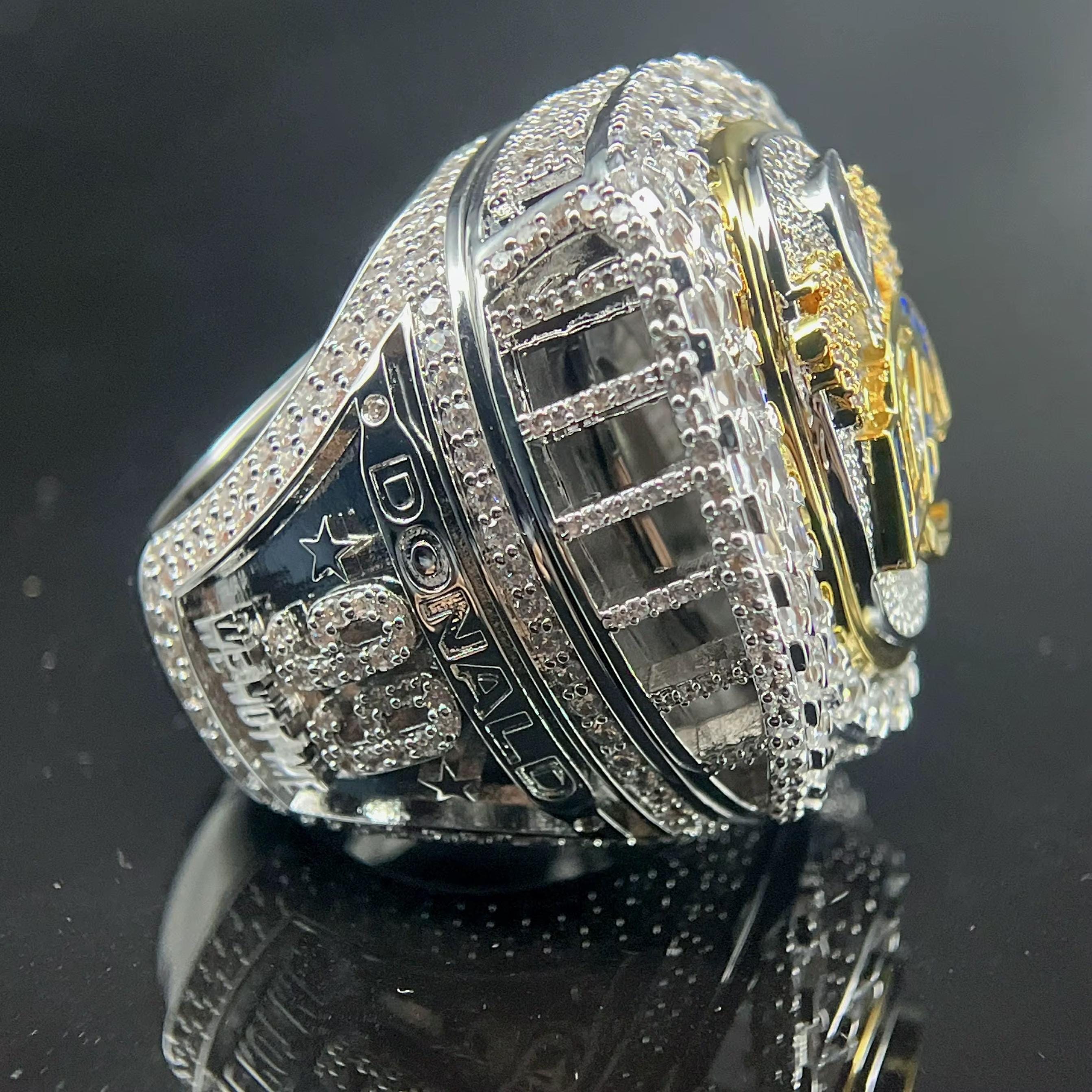 Silver and gold ring with detailed design on a black background