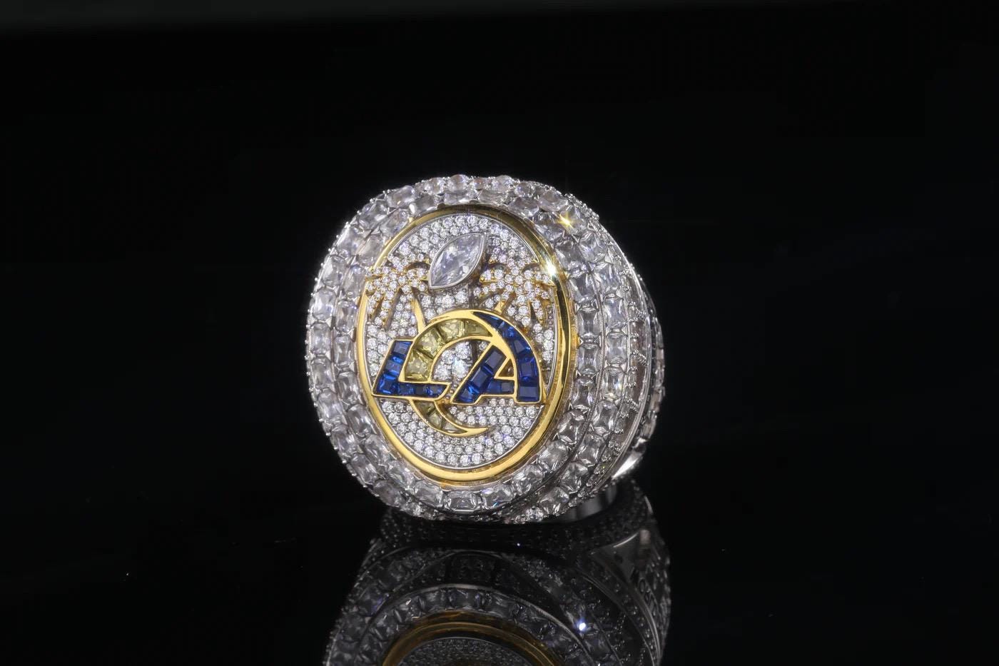 Luxury ring with diamond-studded band and emblem on a black background