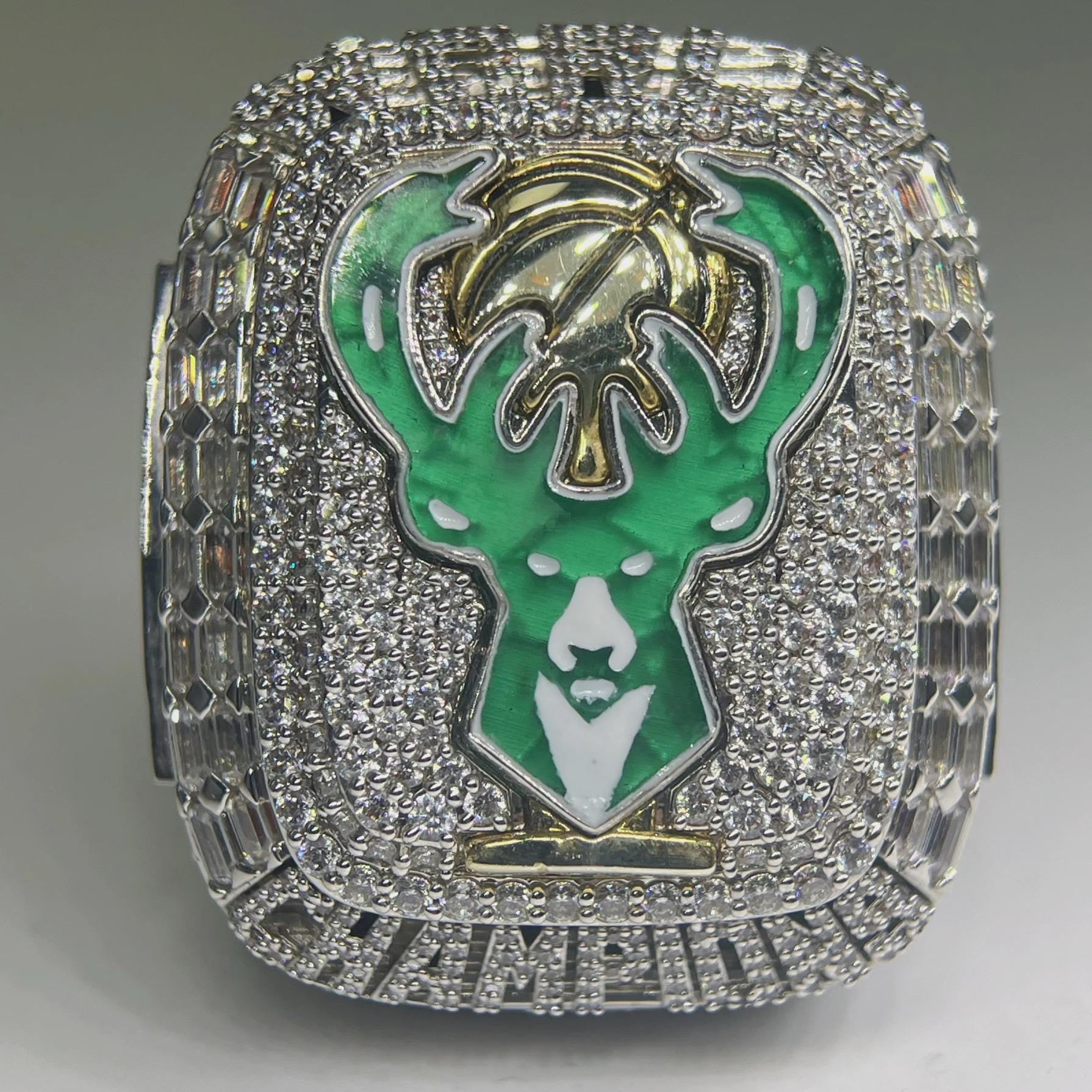 Ring with green and gold emblem on a gray background