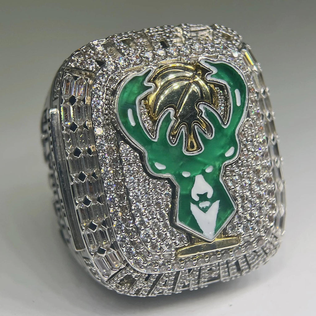 Ring with green and gold emblem on a gray background