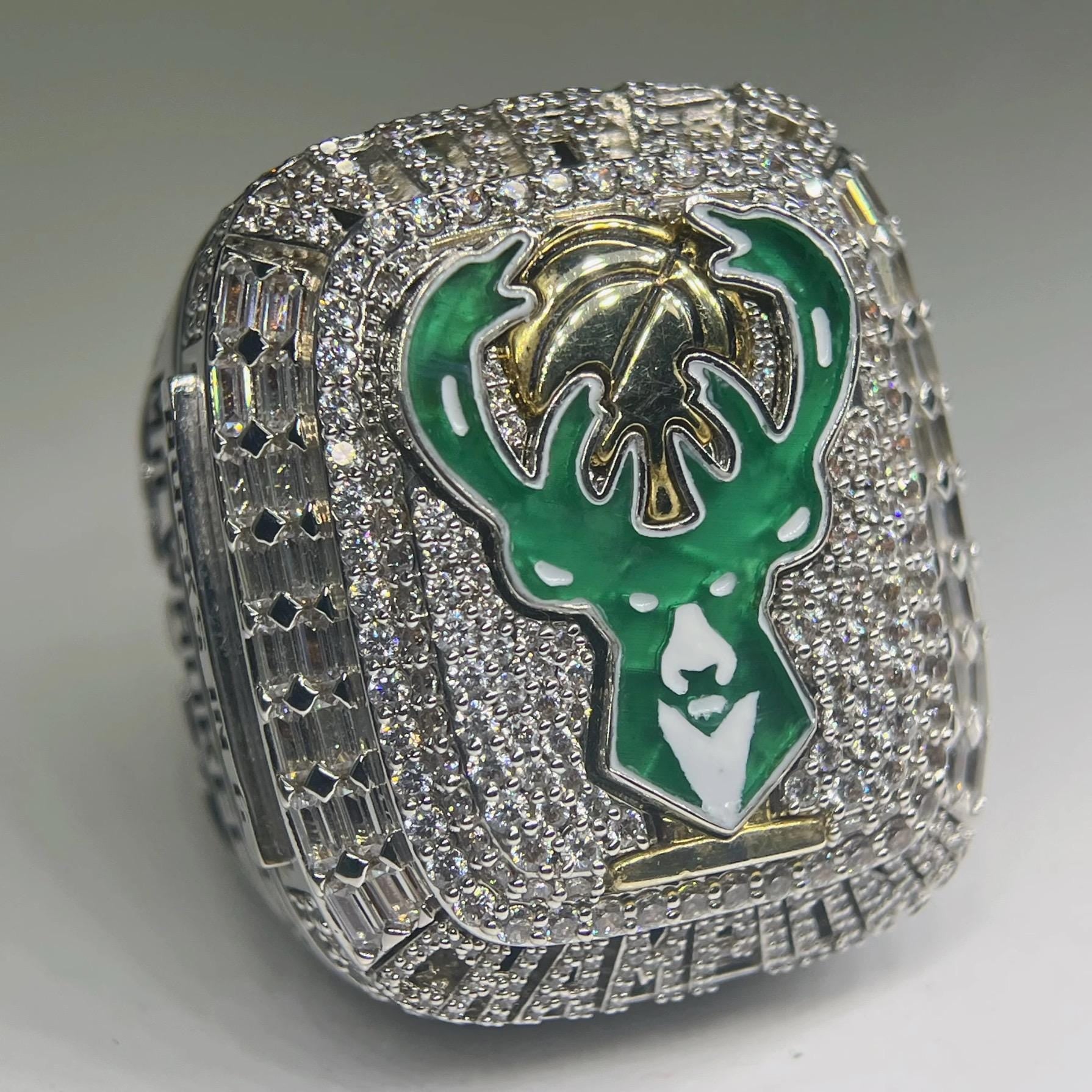 Ring with green and gold emblem on a gray background