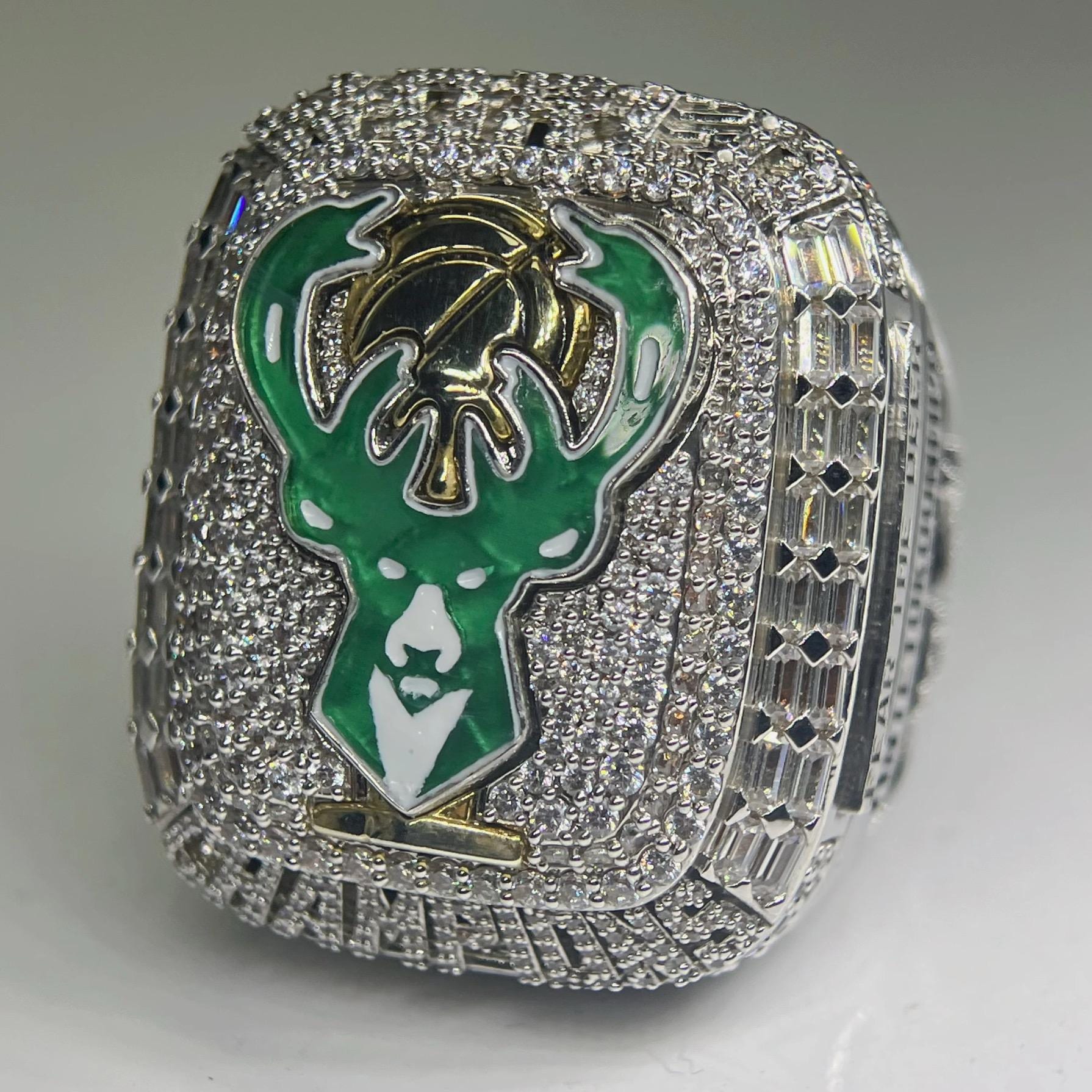 Ring with a green and gold emblem on a gray background