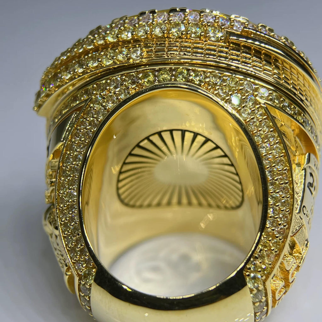 Gold ring with diamond accents on a gray background