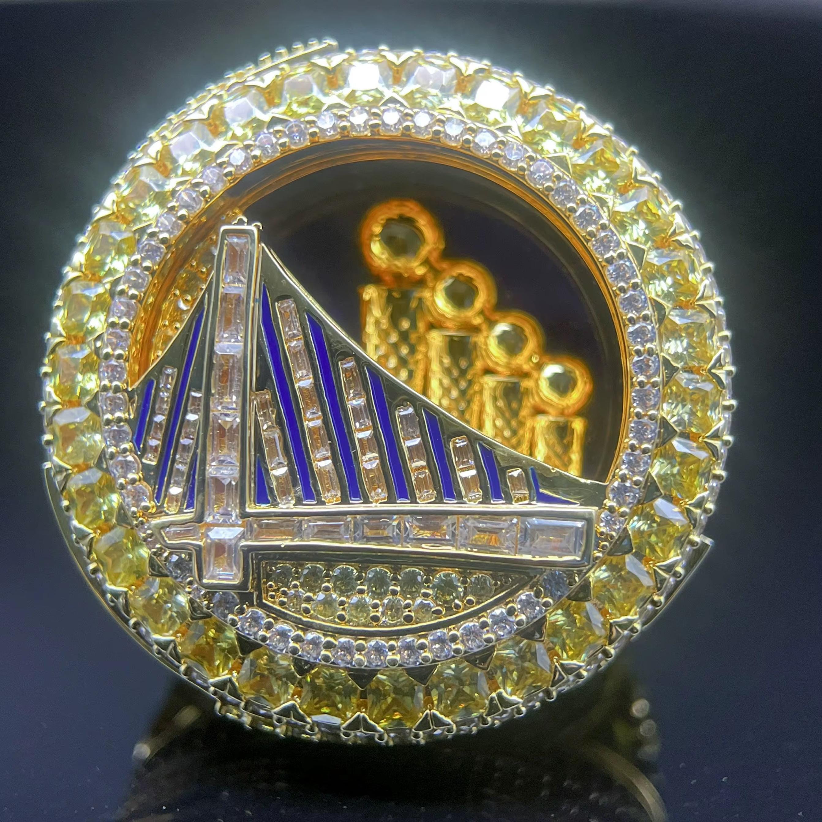 Gold and diamond-encrusted emblem with a bridge design on a dark background