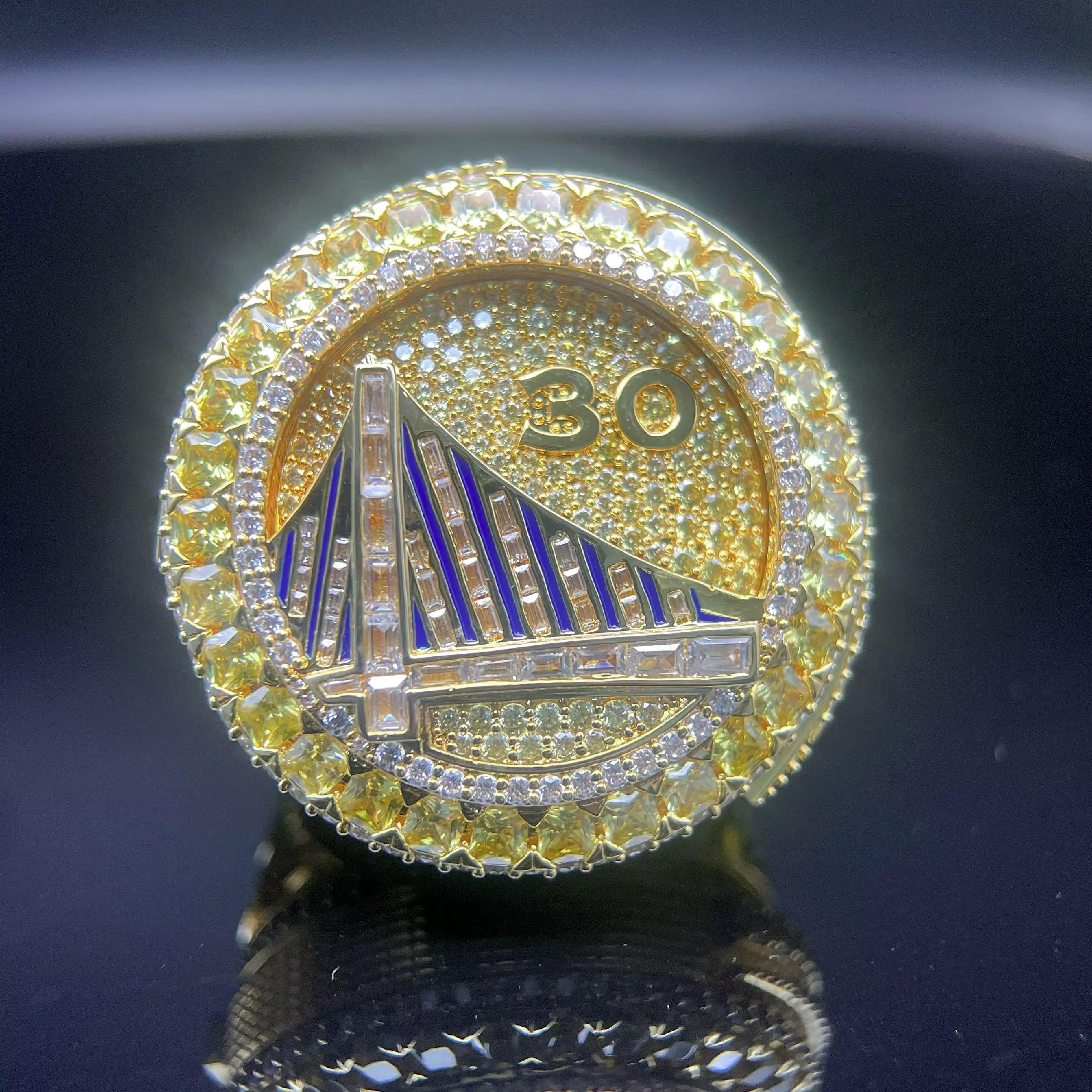 Gold and silver coin with bridge design and number 30 on a dark background