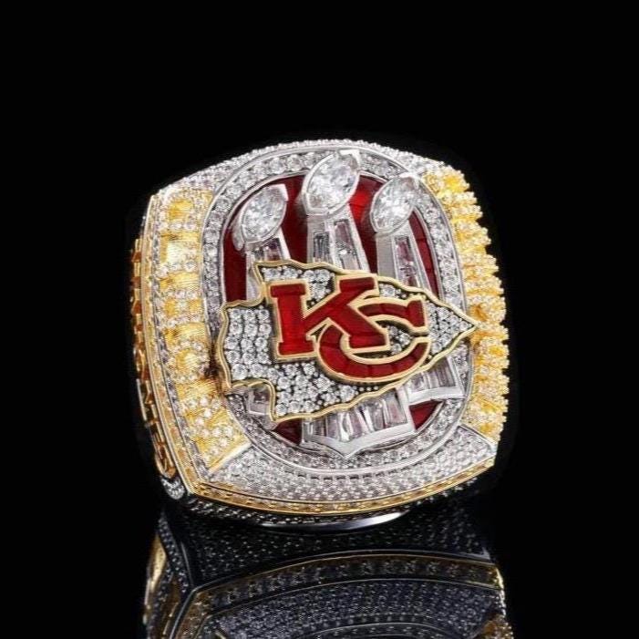 Championship ring with 'KC' logo on a black background