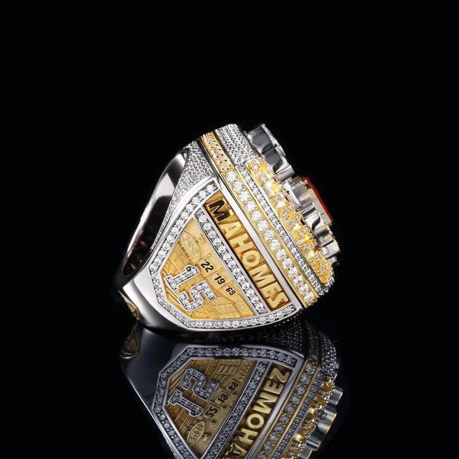 Gold and silver championship ring with 'Mahomes' and 'Super Bowl' text on a black background