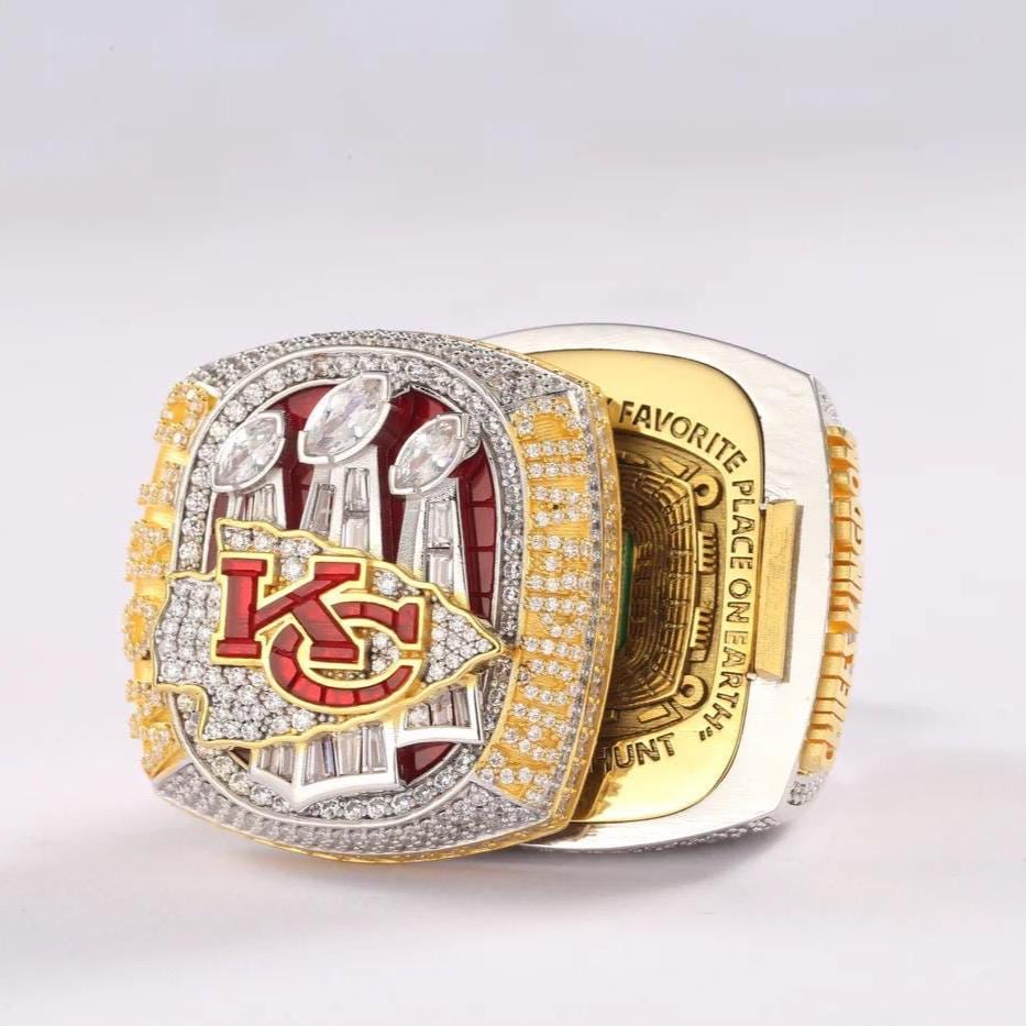 Gold and silver championship ring with red accents on a light gray background