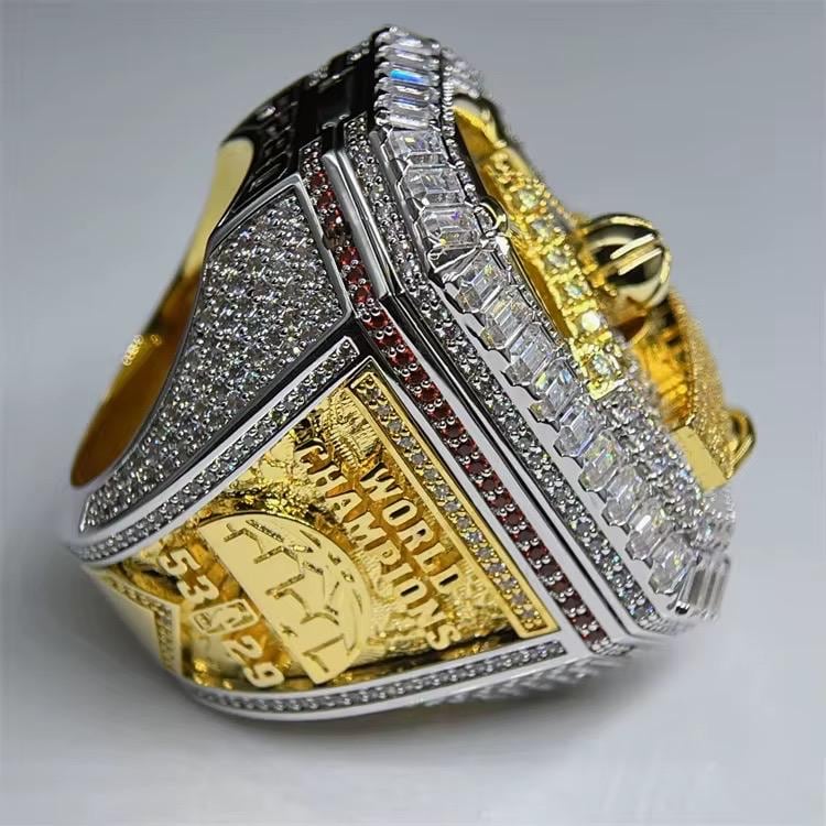 Gold and silver ring with diamond accents on a gray background