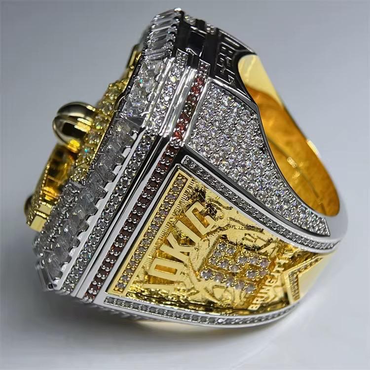 Gold and silver ring with 'Jokic' engraving on a gray background