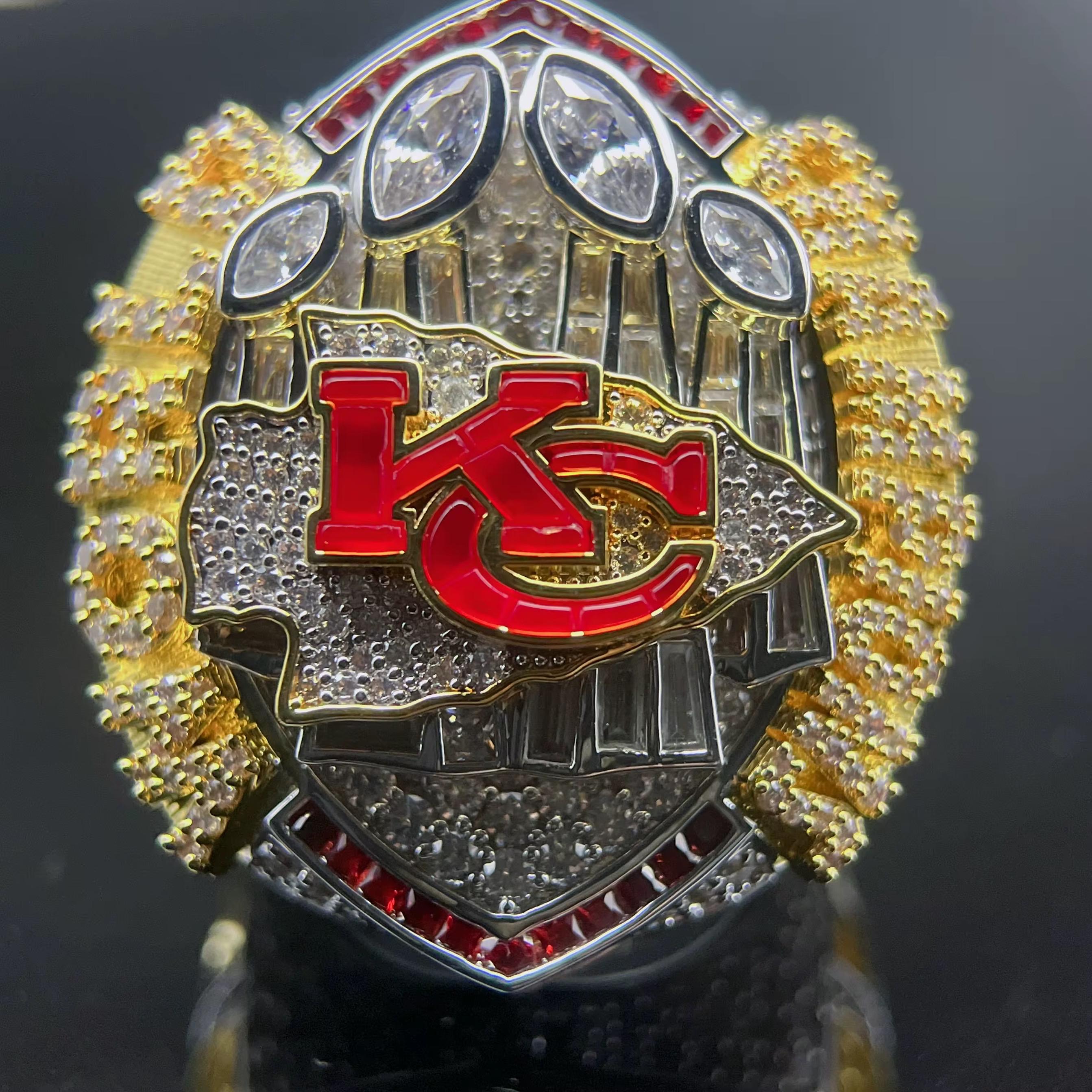 Close-up of a championship ring with 'KC' logo on a dark background