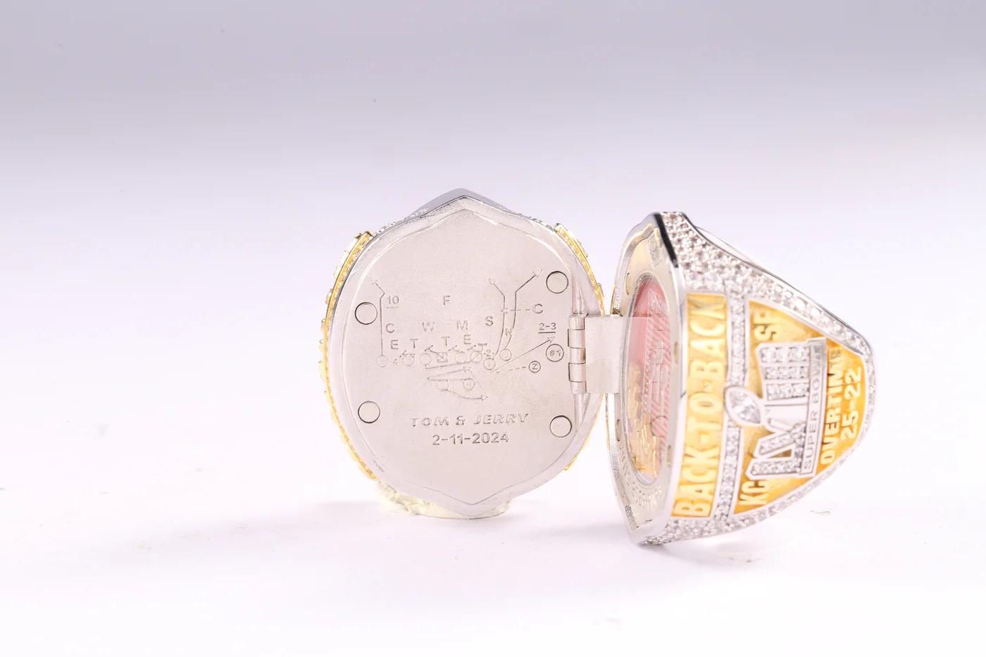 Gold championship ring with engraved details on a white background