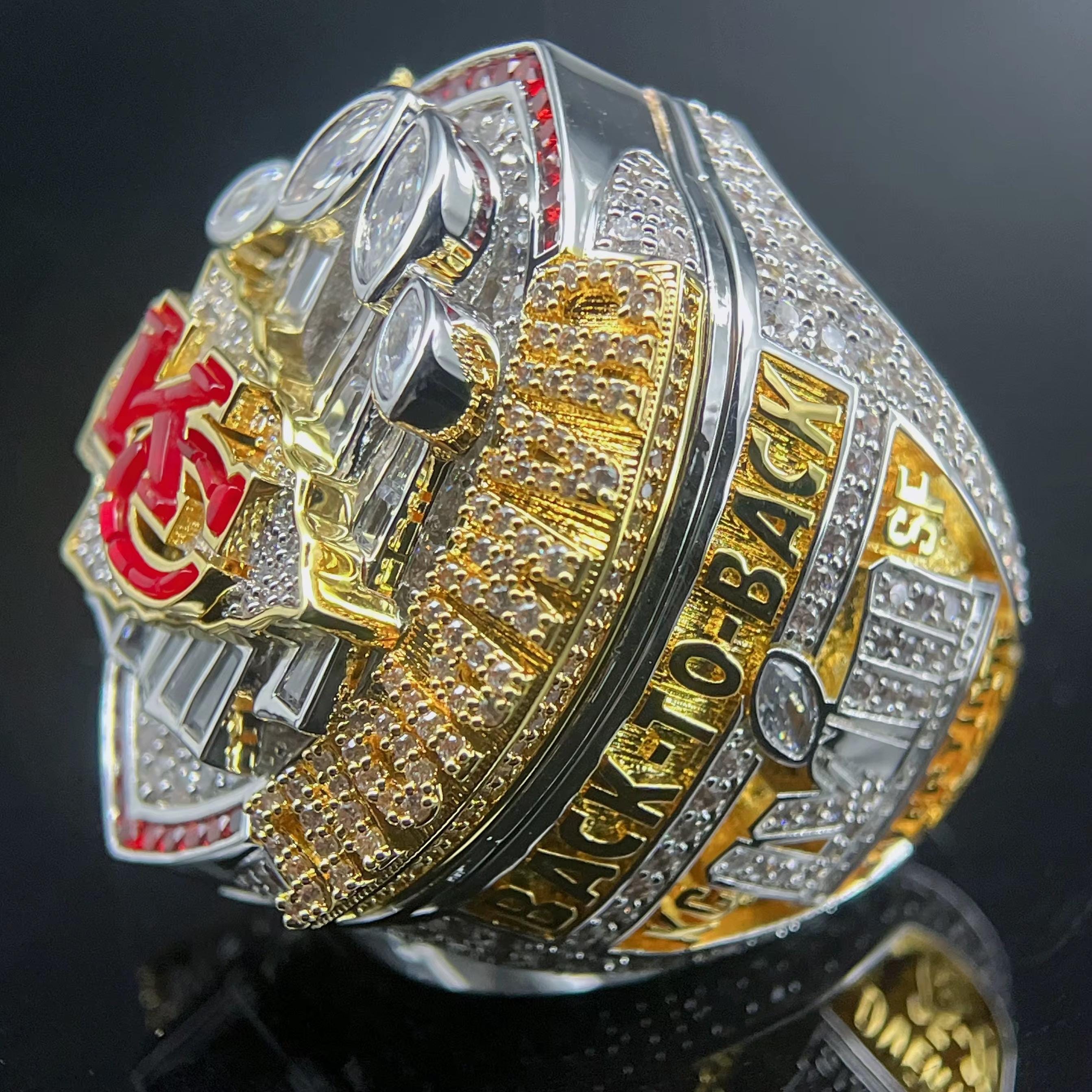 Gold and silver championship ring with red accents on a black background