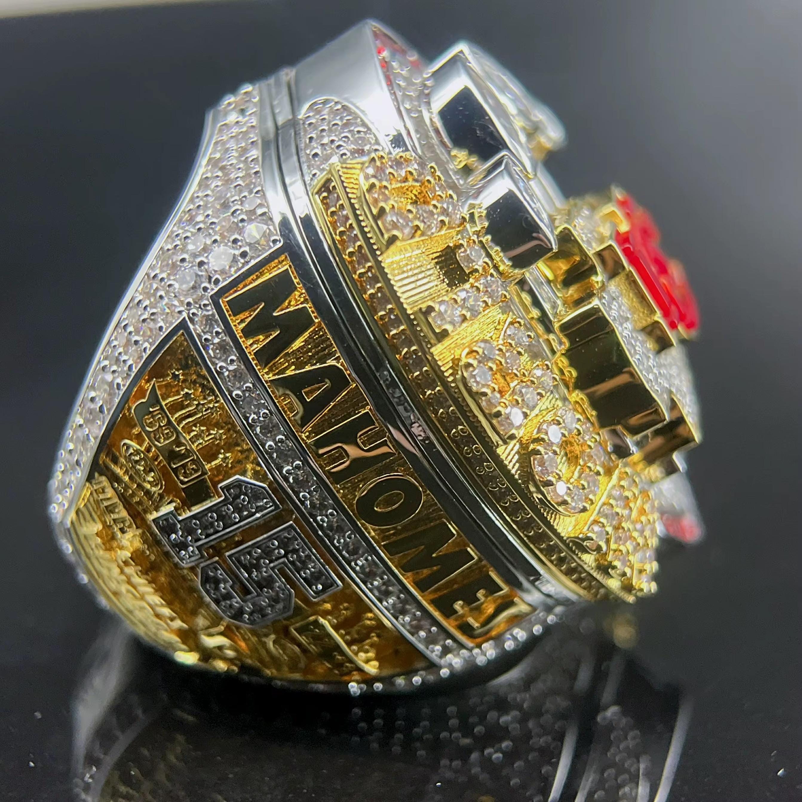 Gold and silver championship ring with 'Mahomes' engraved on a black background