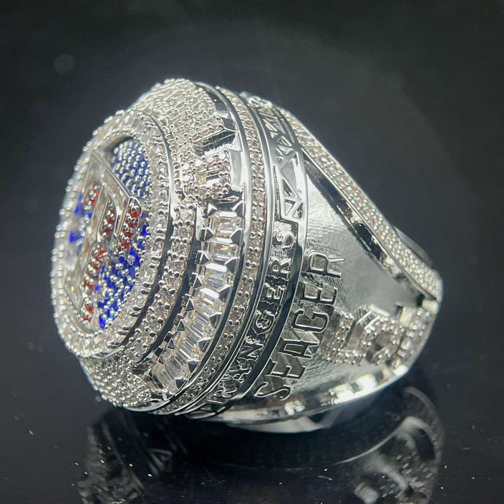 Silver ring with detailed design on a reflective black surface